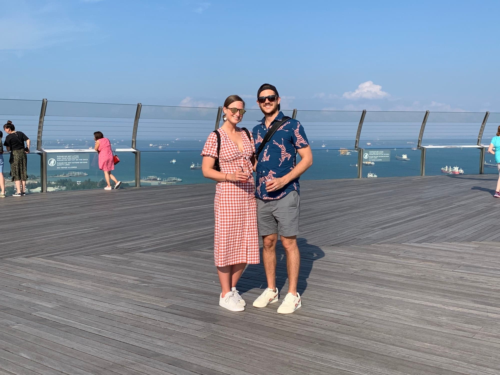 A man and woman standing in front of ocean.