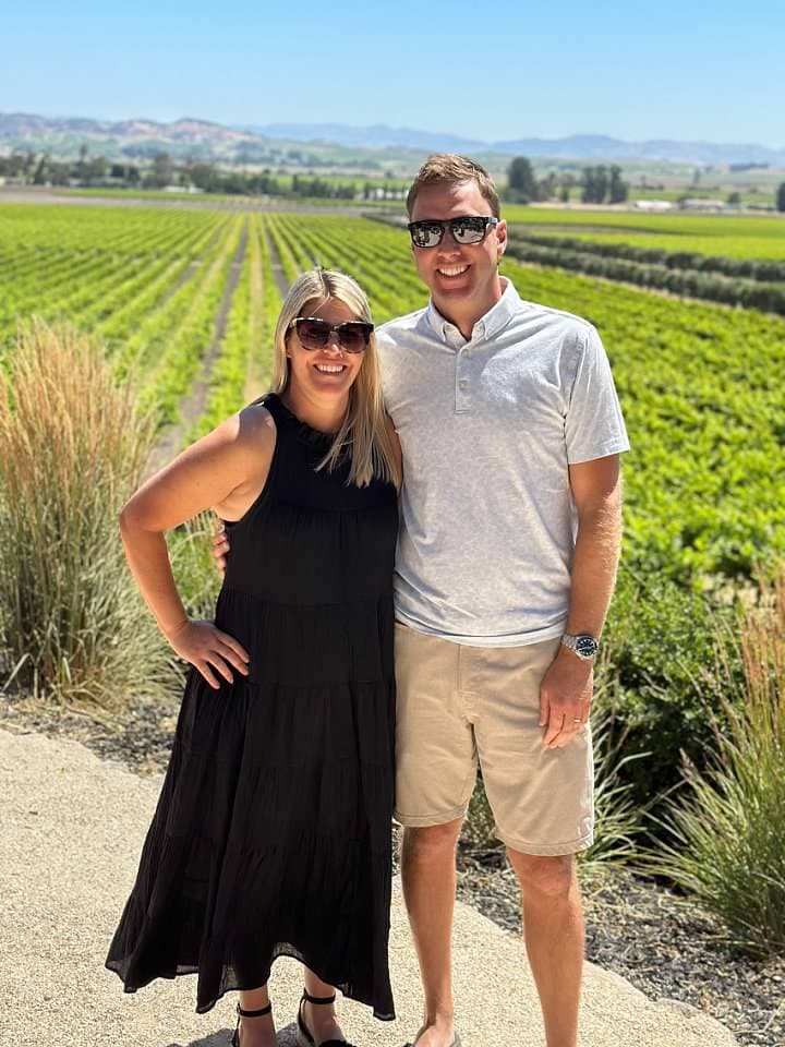 Posing for a couple photo with the beautiful view of the green fields in the background