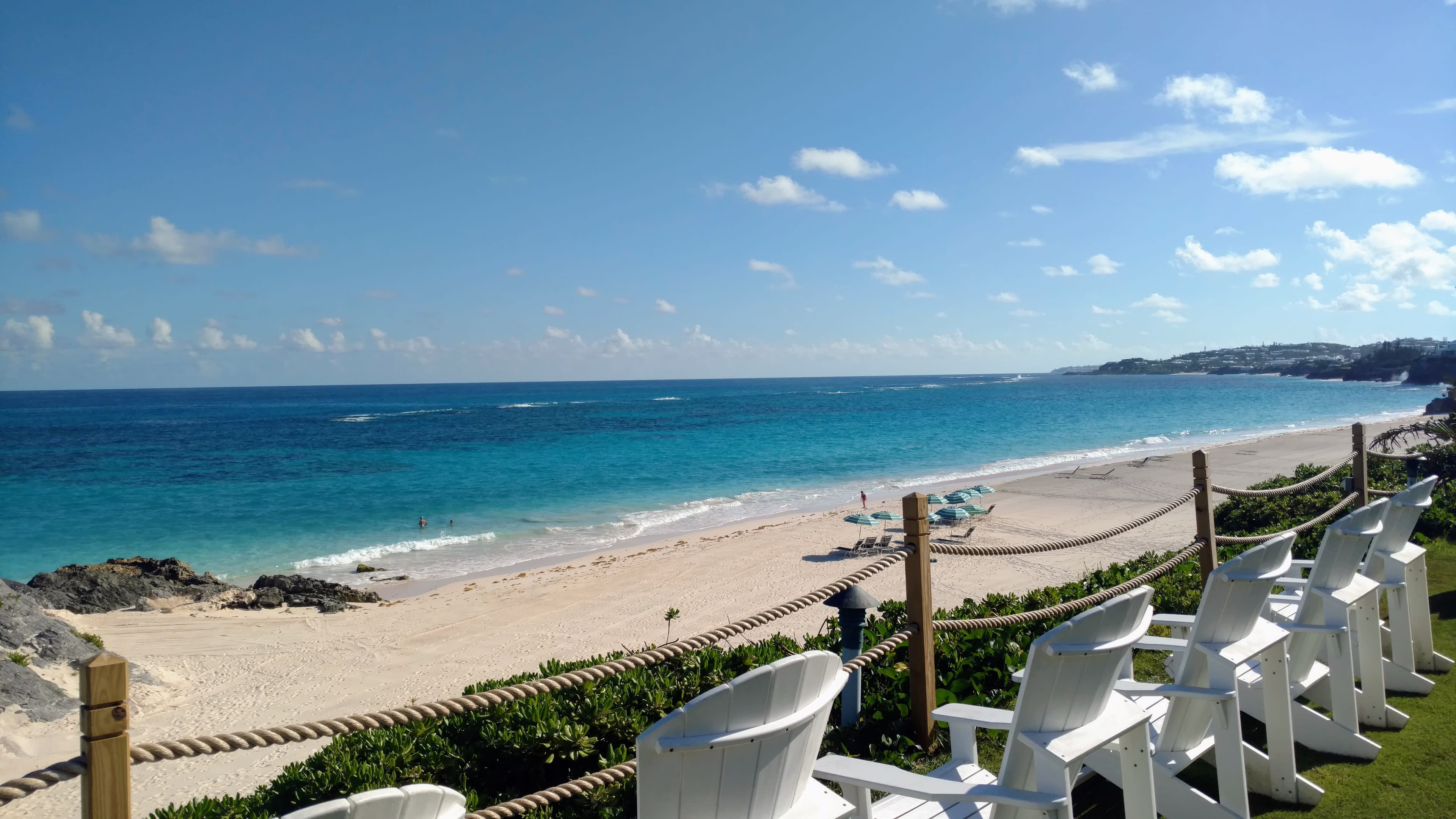 Beautiful view of Bermuda beach with beach chairs on a sunny day with a clear sky.