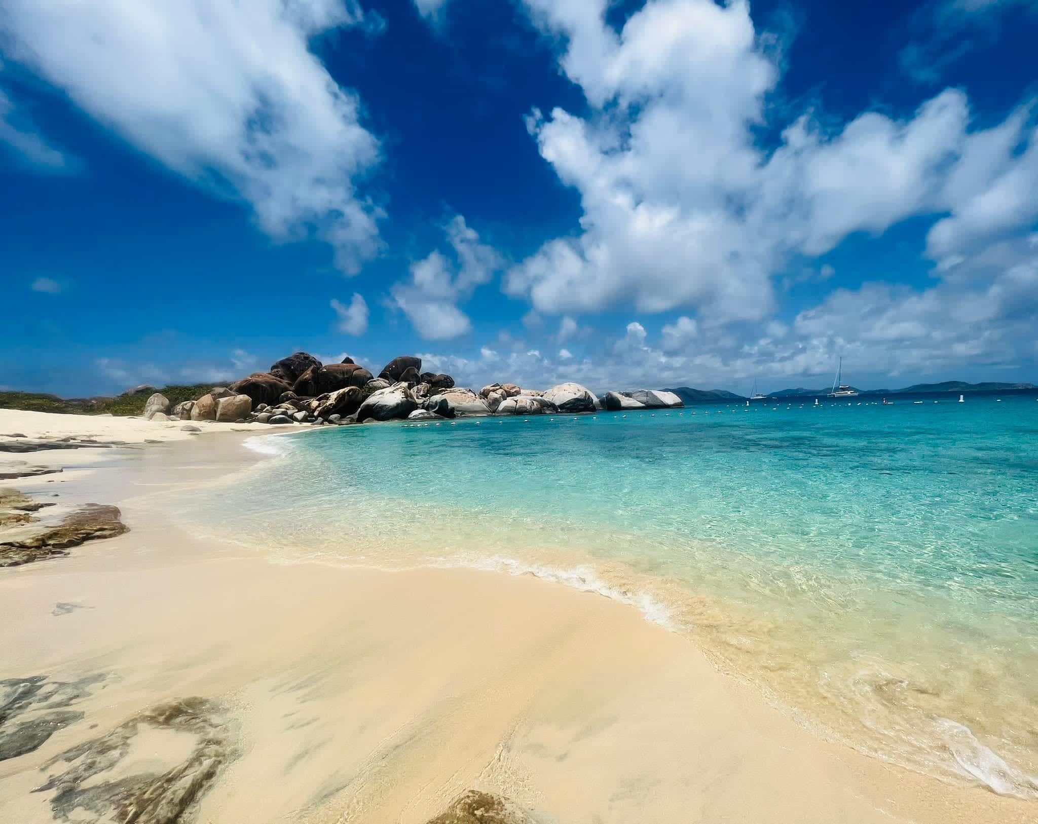 Beautiful view of beach with turquoise colored water and rock formations in the distance