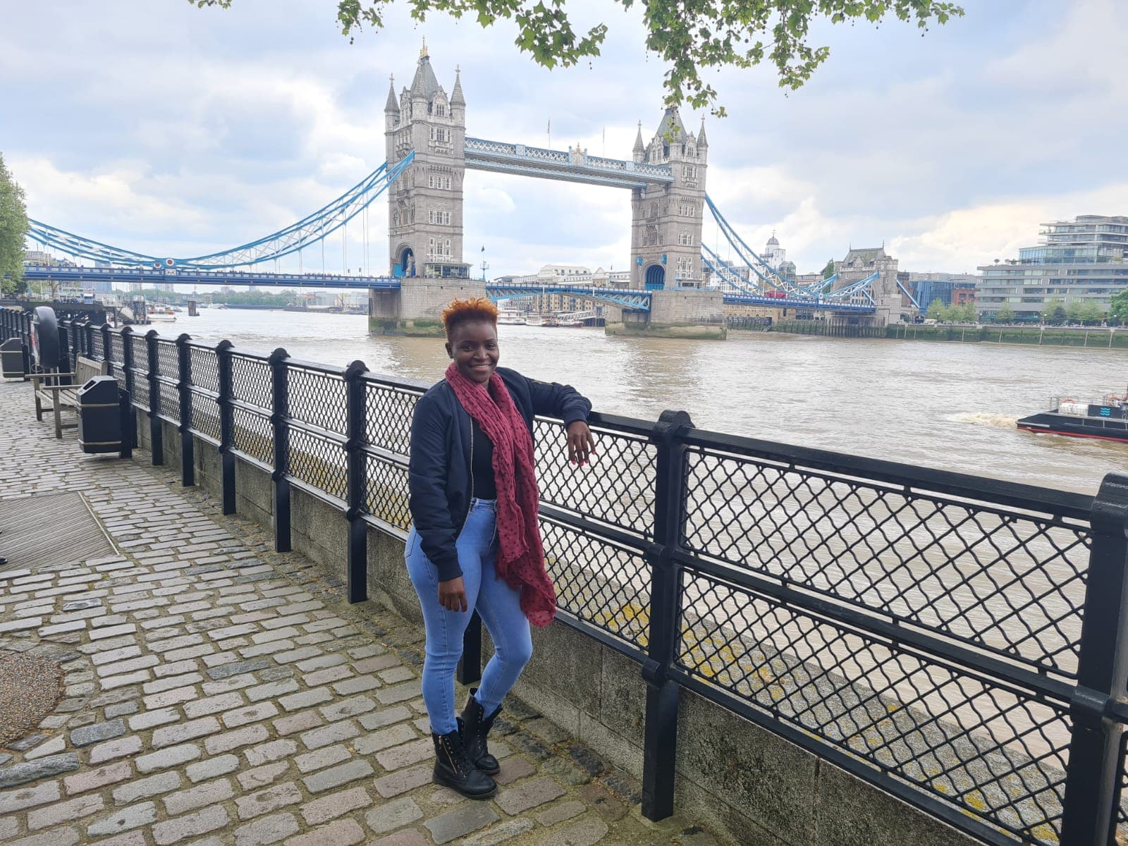 Posing for a photo in London by the river with Tower Bridge in view