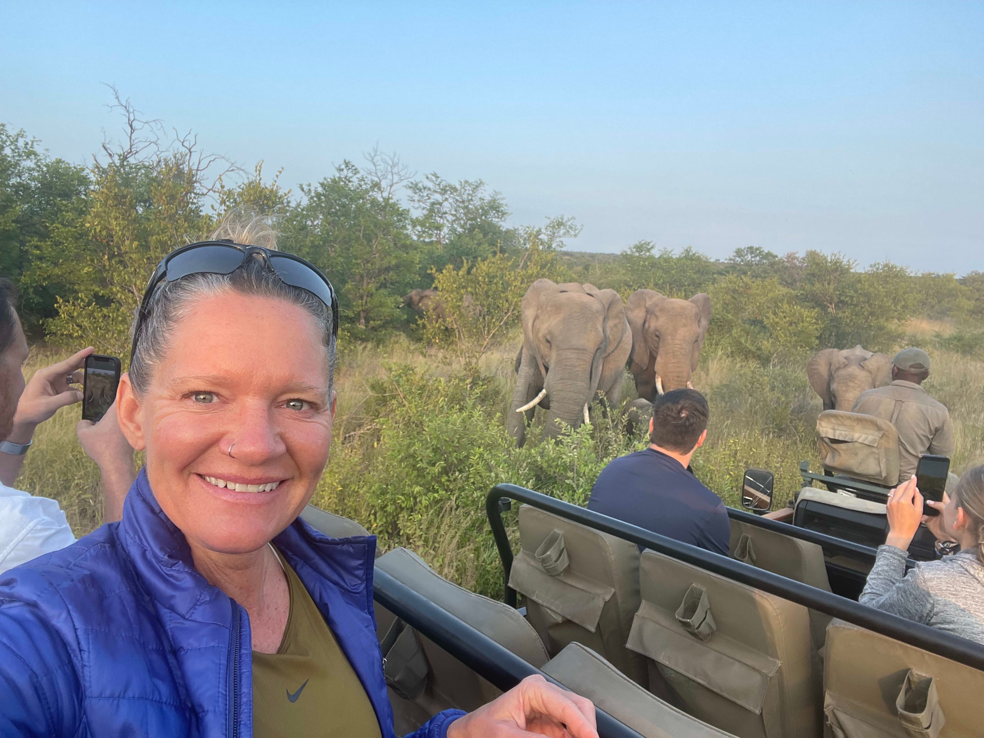 Pitcture of Dayna on a safari at Kruger National Park with an elephant grazing in the background