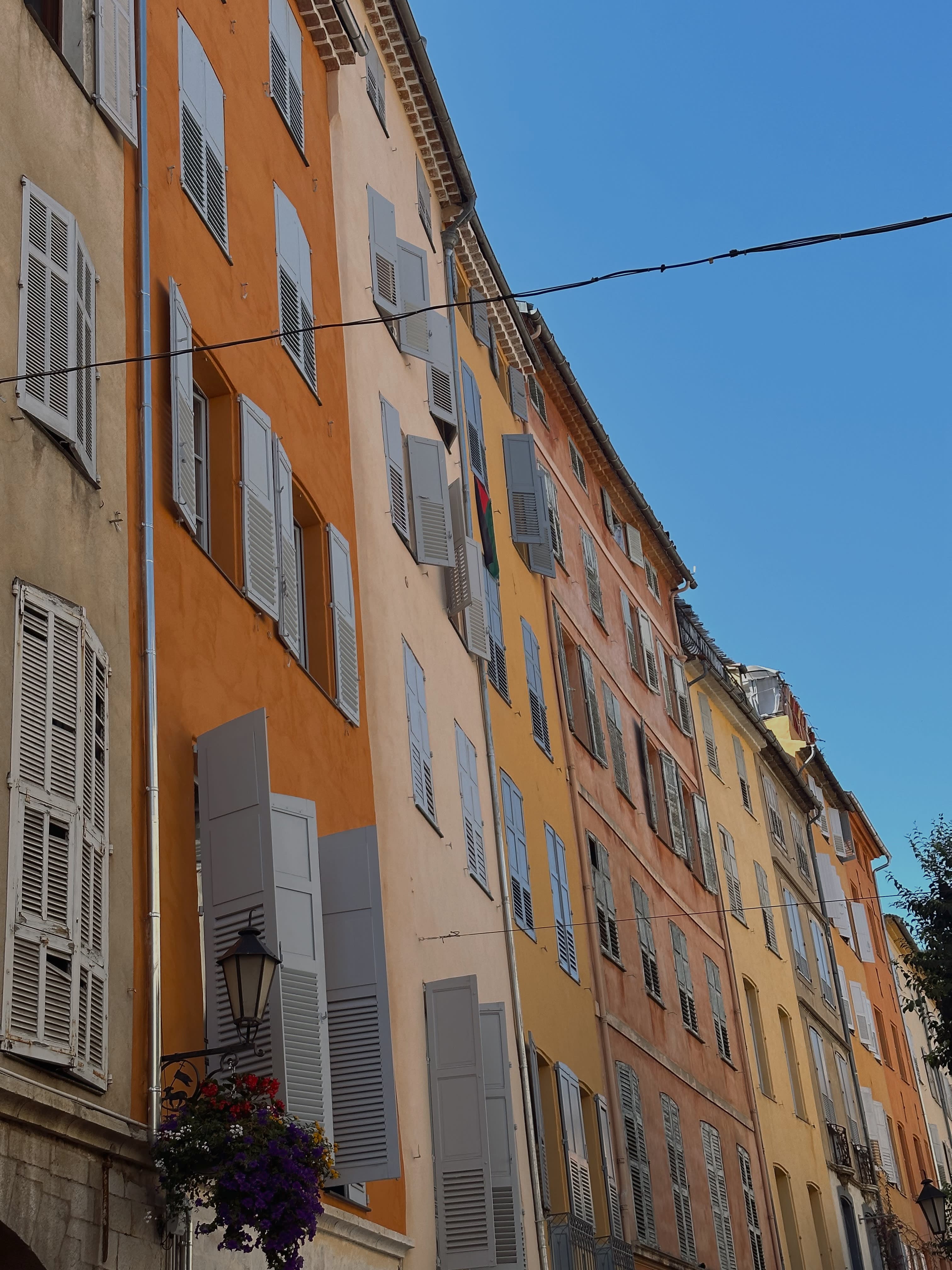 View of European style buildings painted shades of orange with white window shutters on all windows