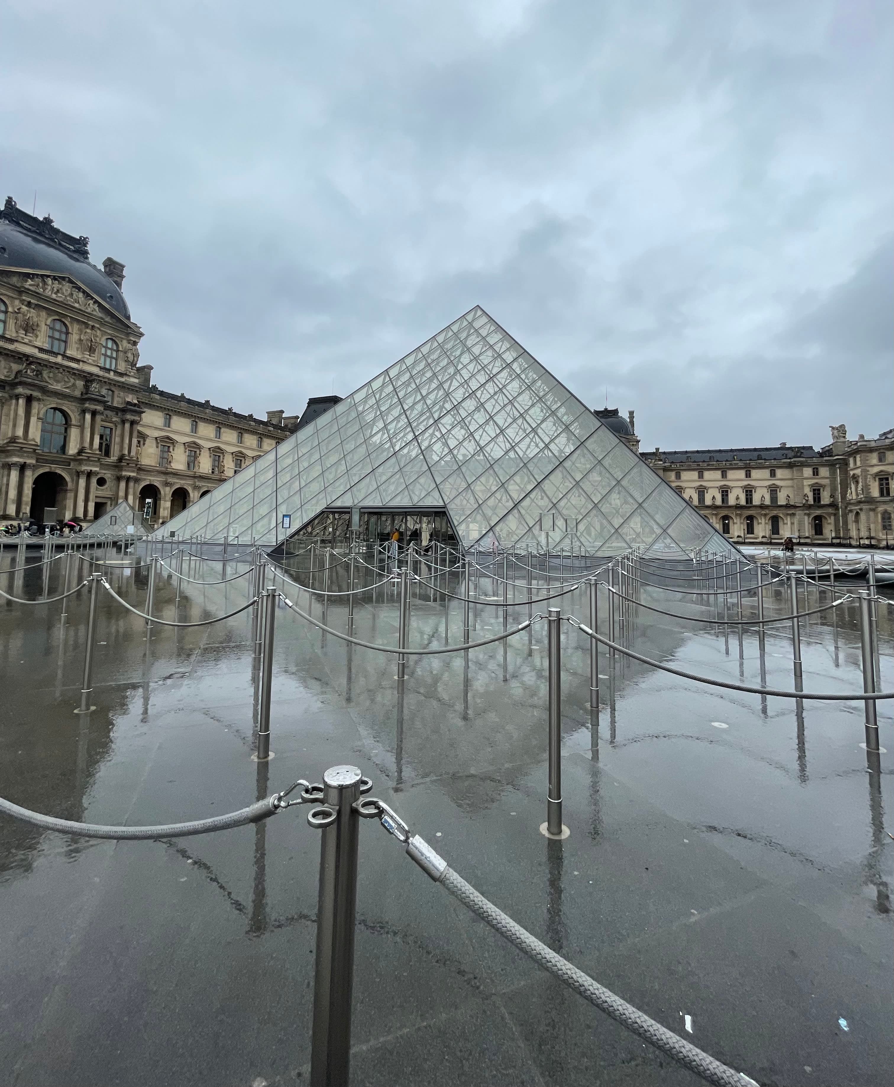 Photo of the glass pyramid at the Louvre on a cloudy rainy day