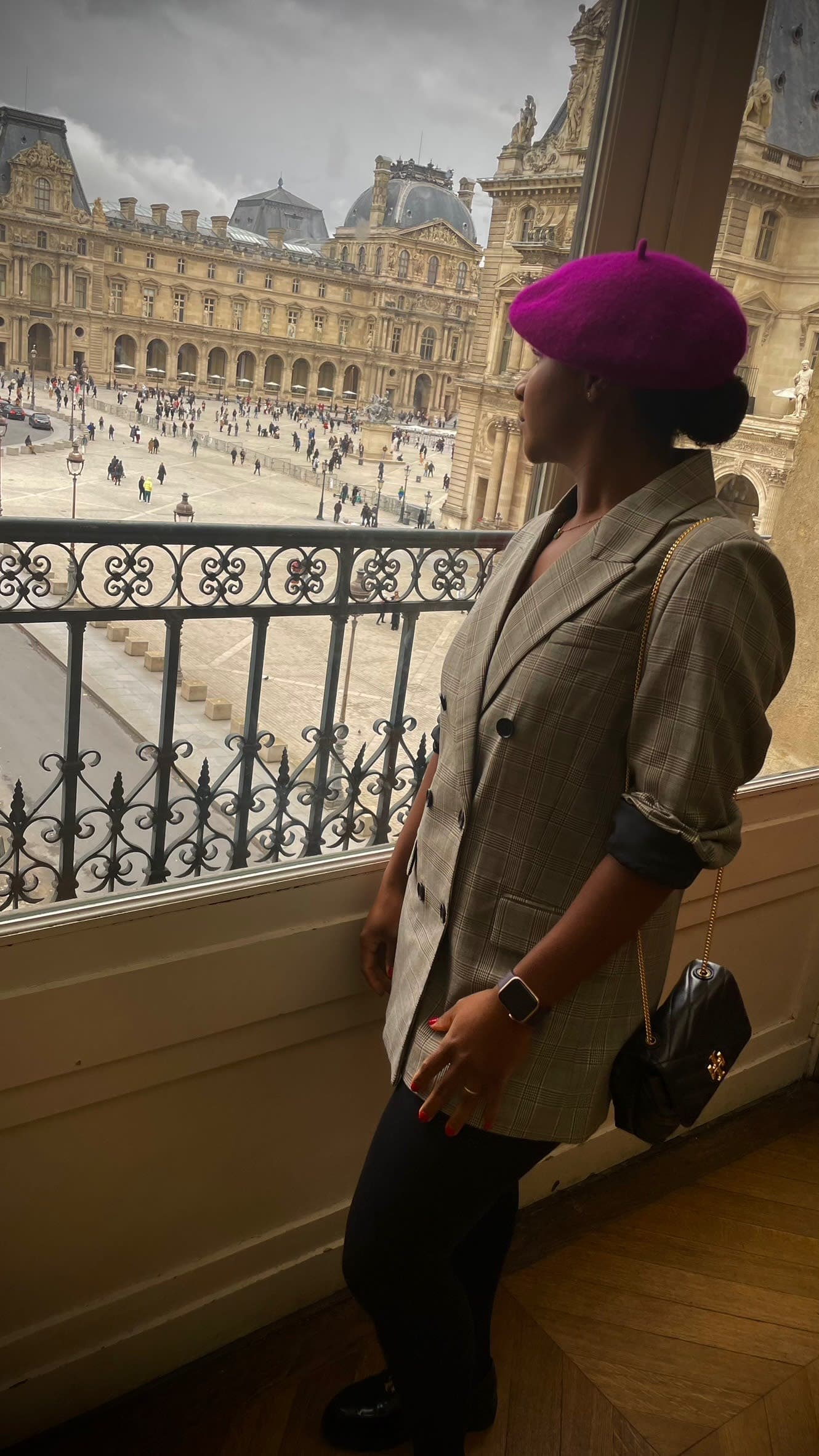 Advisor in a pink beret looking out over a plaza in Europe during the day
