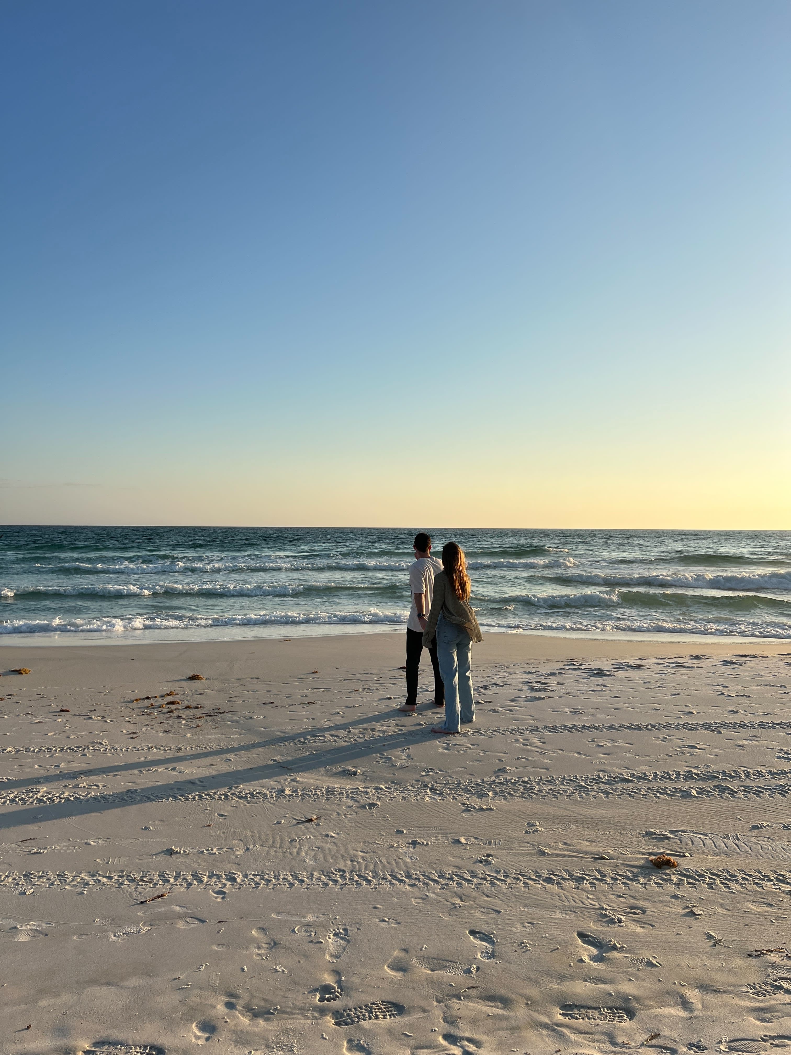 Couple posing on the beach at sunset