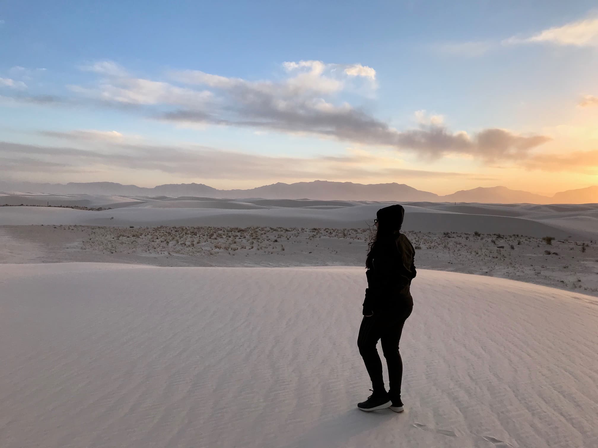 Travel advisor standing on expansive white landscape with the sun low in the sky