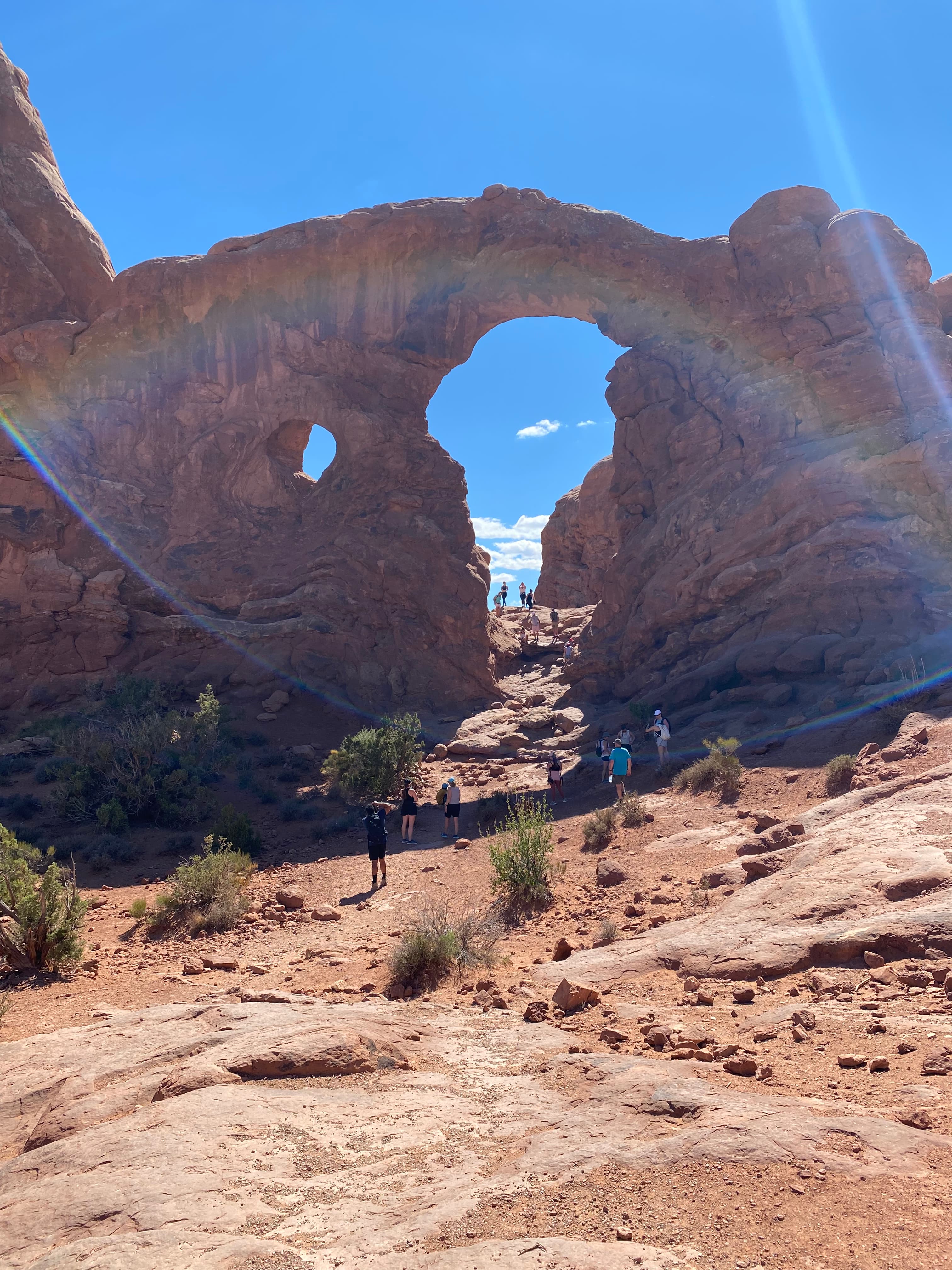 A desert view of a rock formation with a large opening between the rocks.