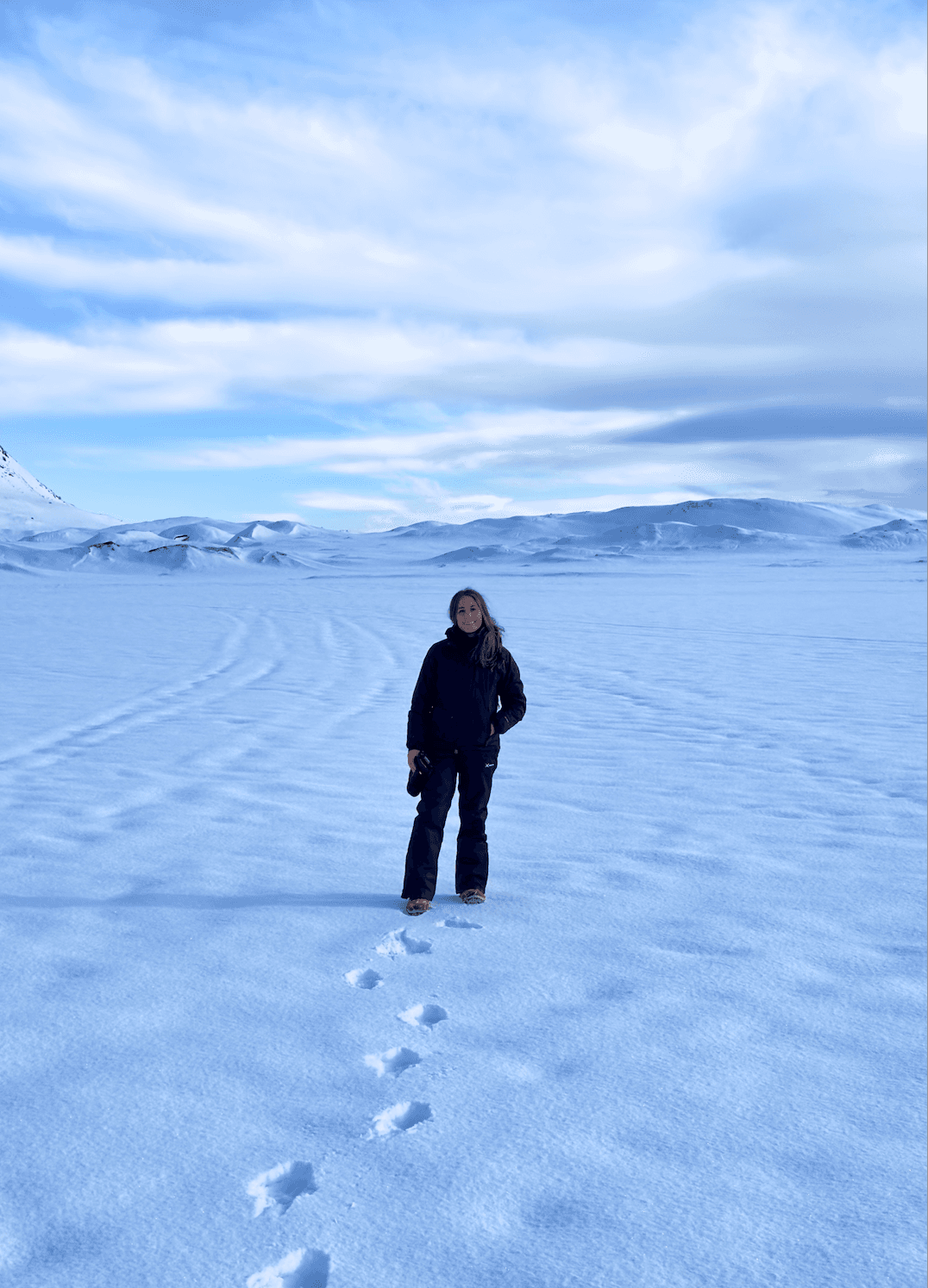 Sofia wearing winter clothes and standing in the middle of an empty snow-covered landscape