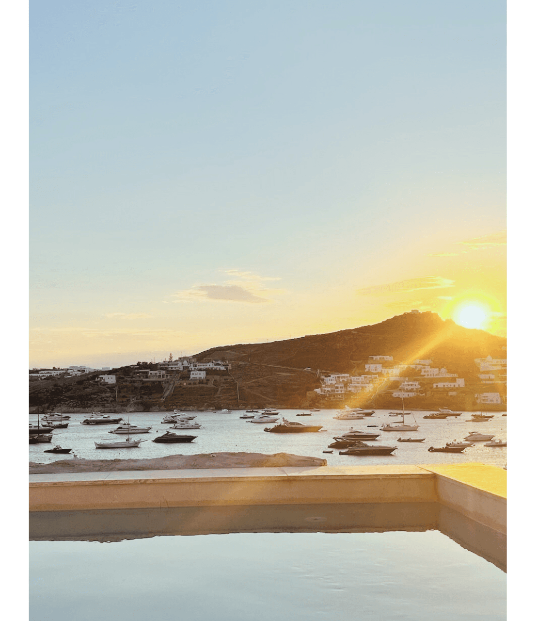 Image of sun setting over a mountain range in a snowy region.