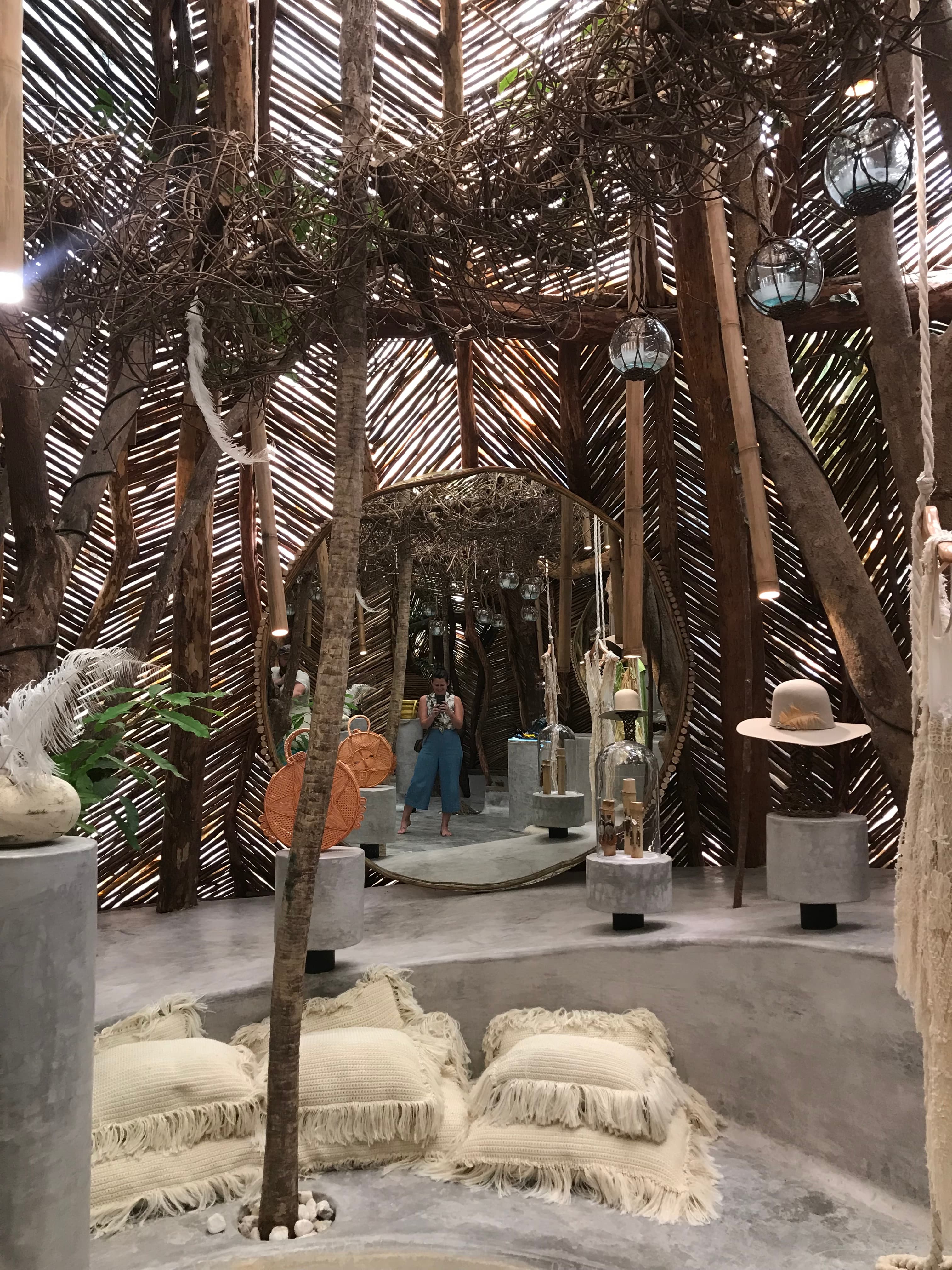 Imagine of white cushions and sculptures positioned outdoors underneath palm trees