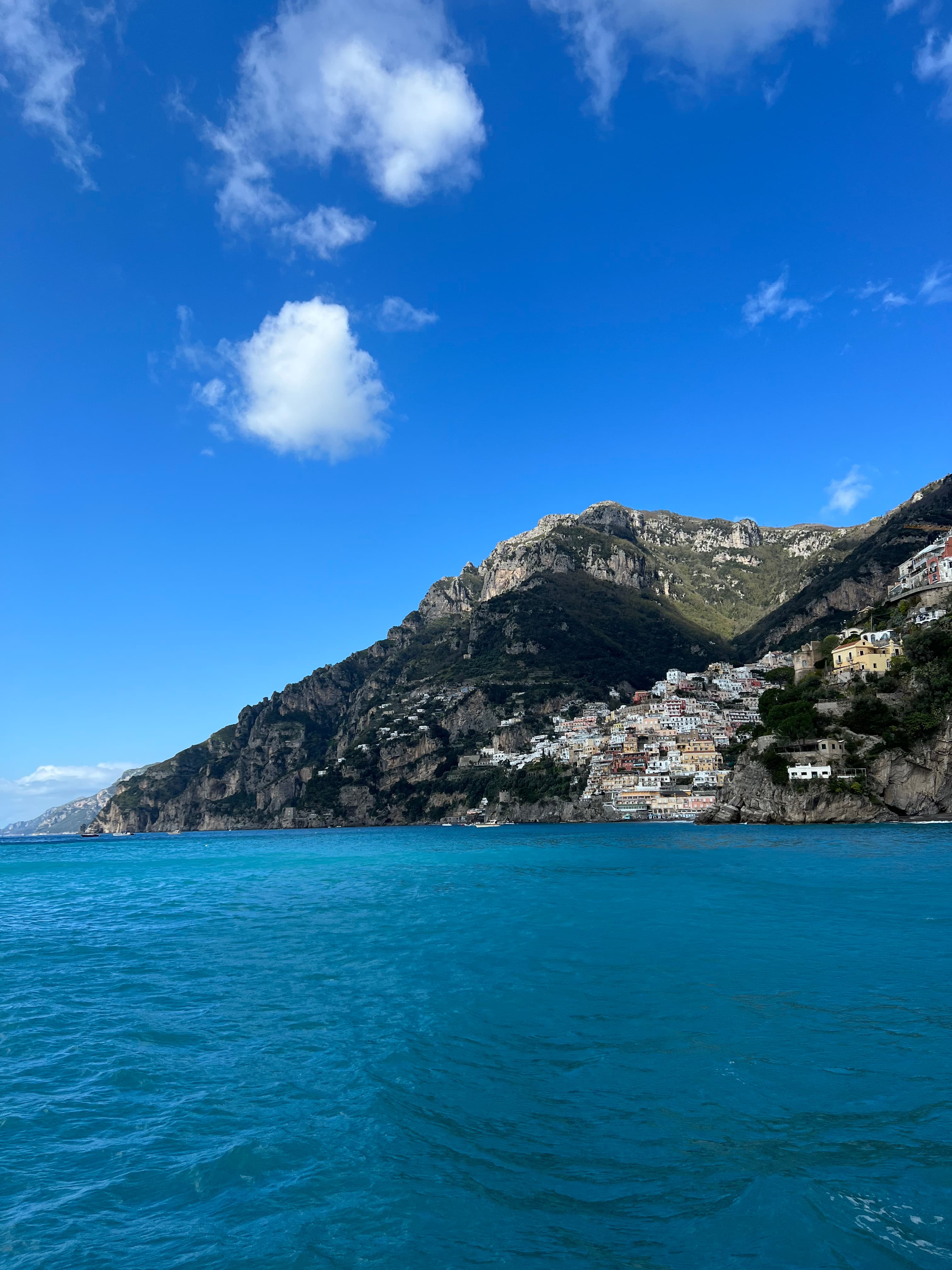 A view of the ocean with cliffs going into the water on a sunny day.