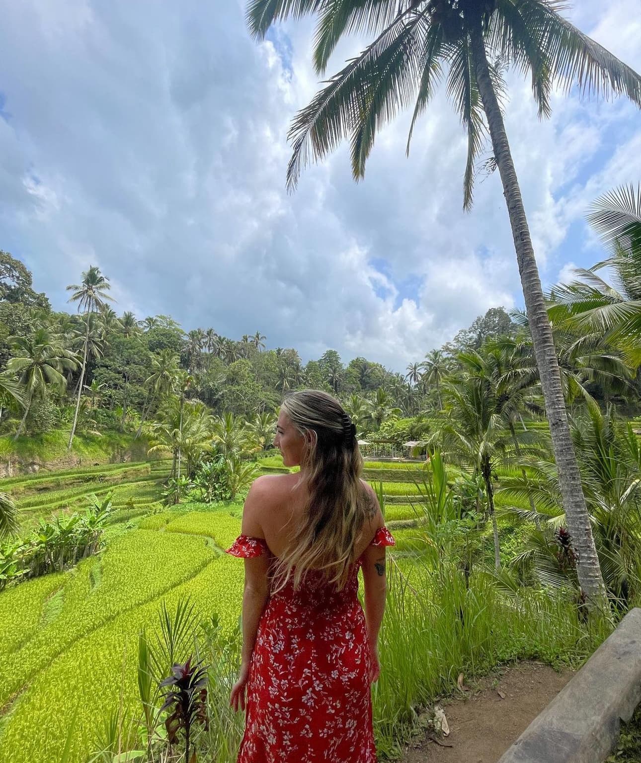 Advisor posing with a green field in the distance on a sunny day.