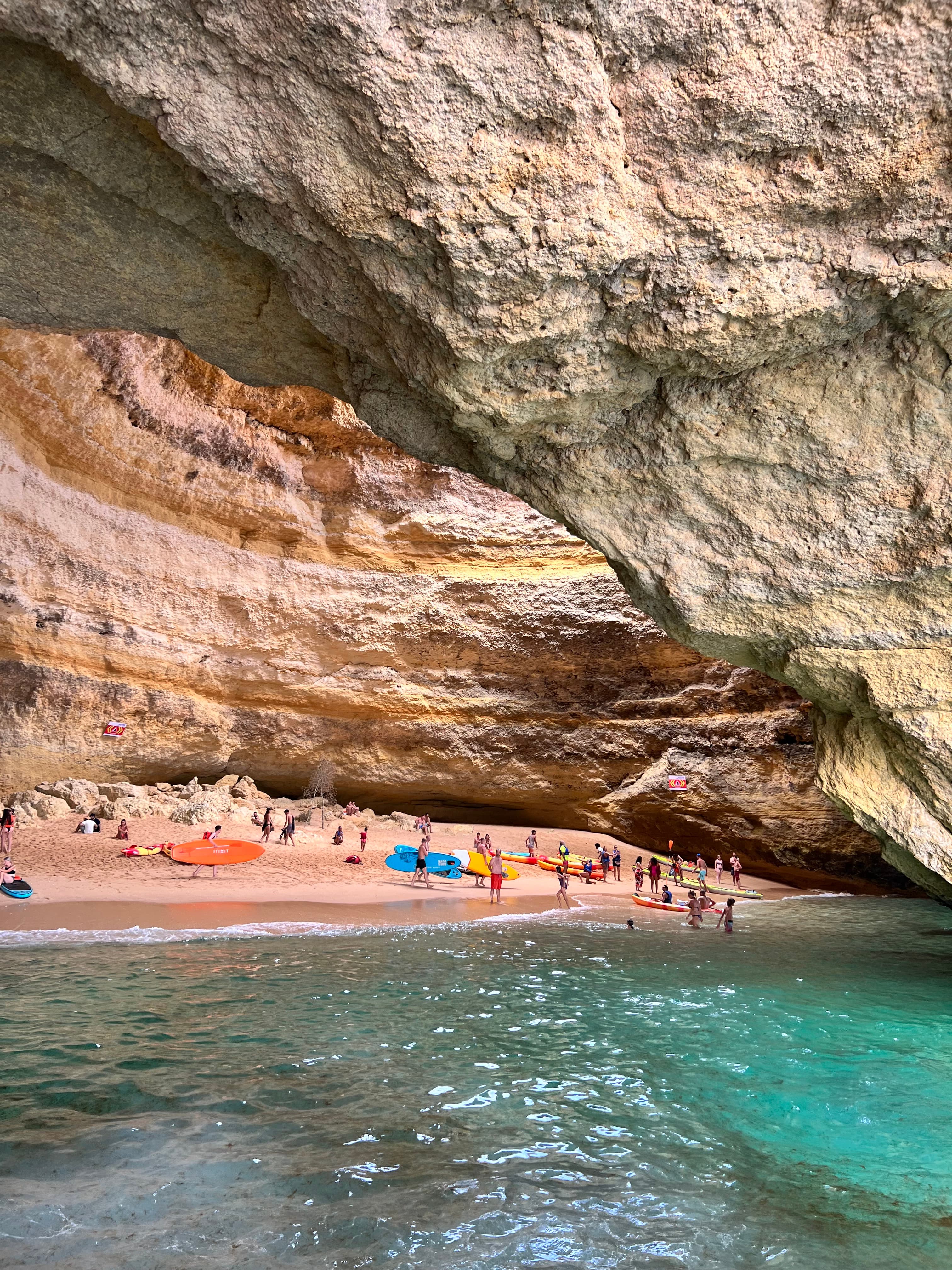 Beautiful view a secluded beach with many people hidden underneath large rock formations