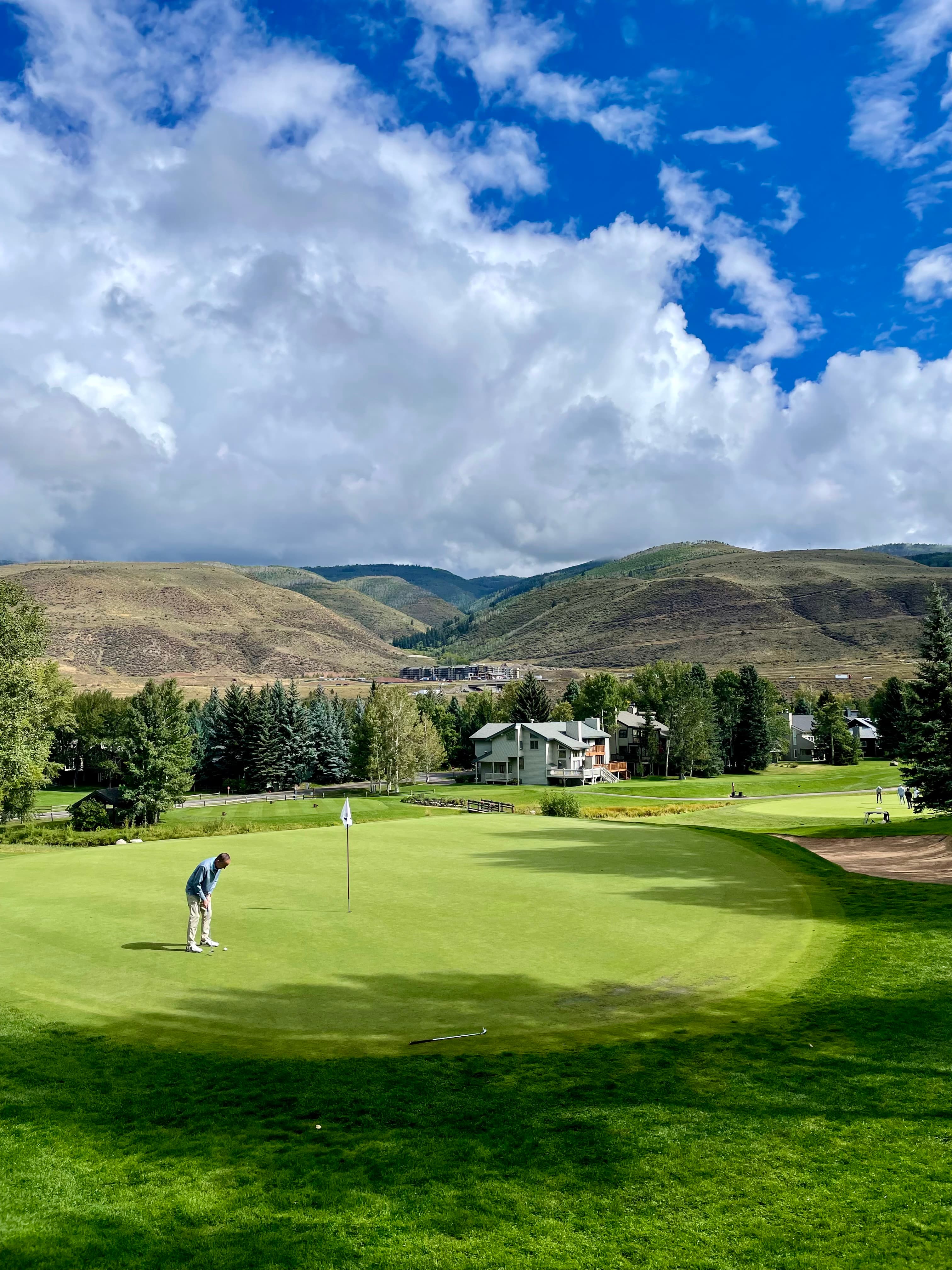 Advisor on a putting green on a gold course on a sunny day.