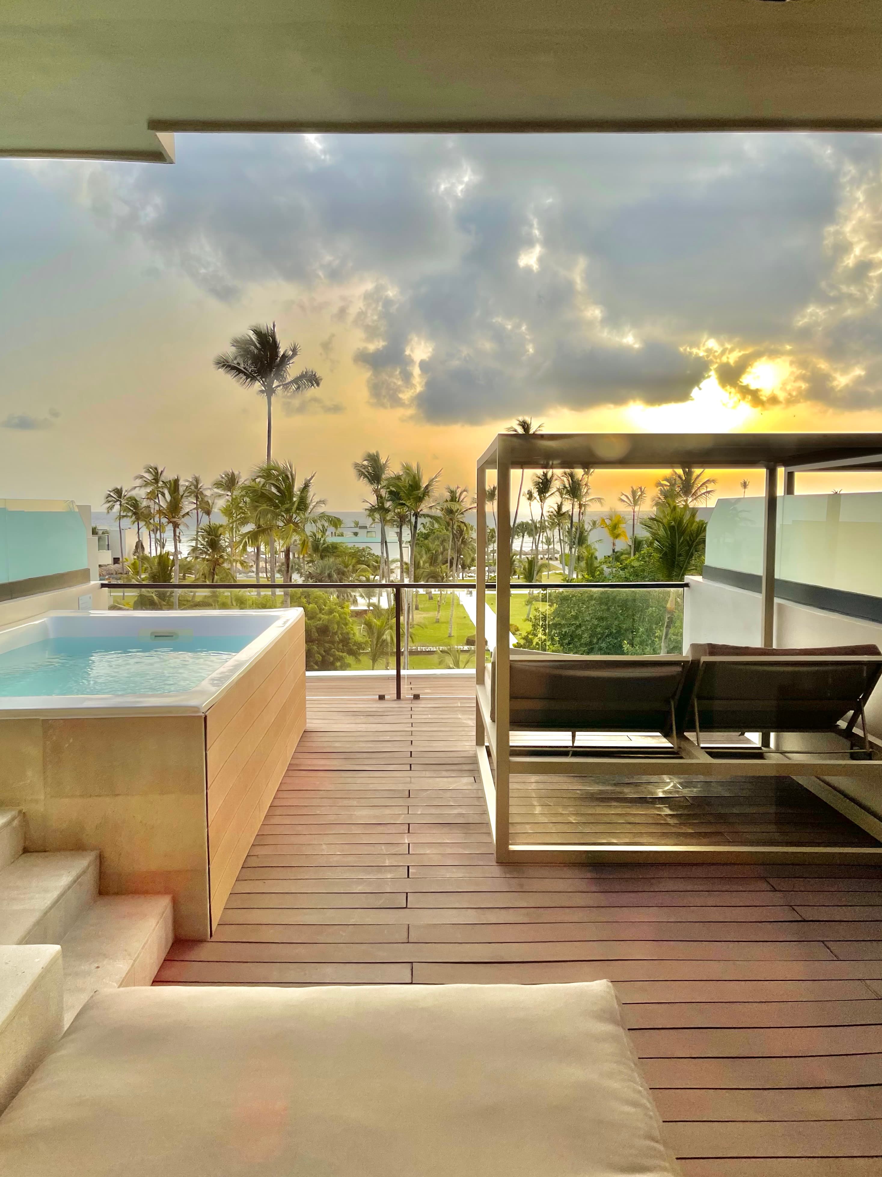 An image of a hotel room deck with a private pool and a lounger for relaxing during the daytime.