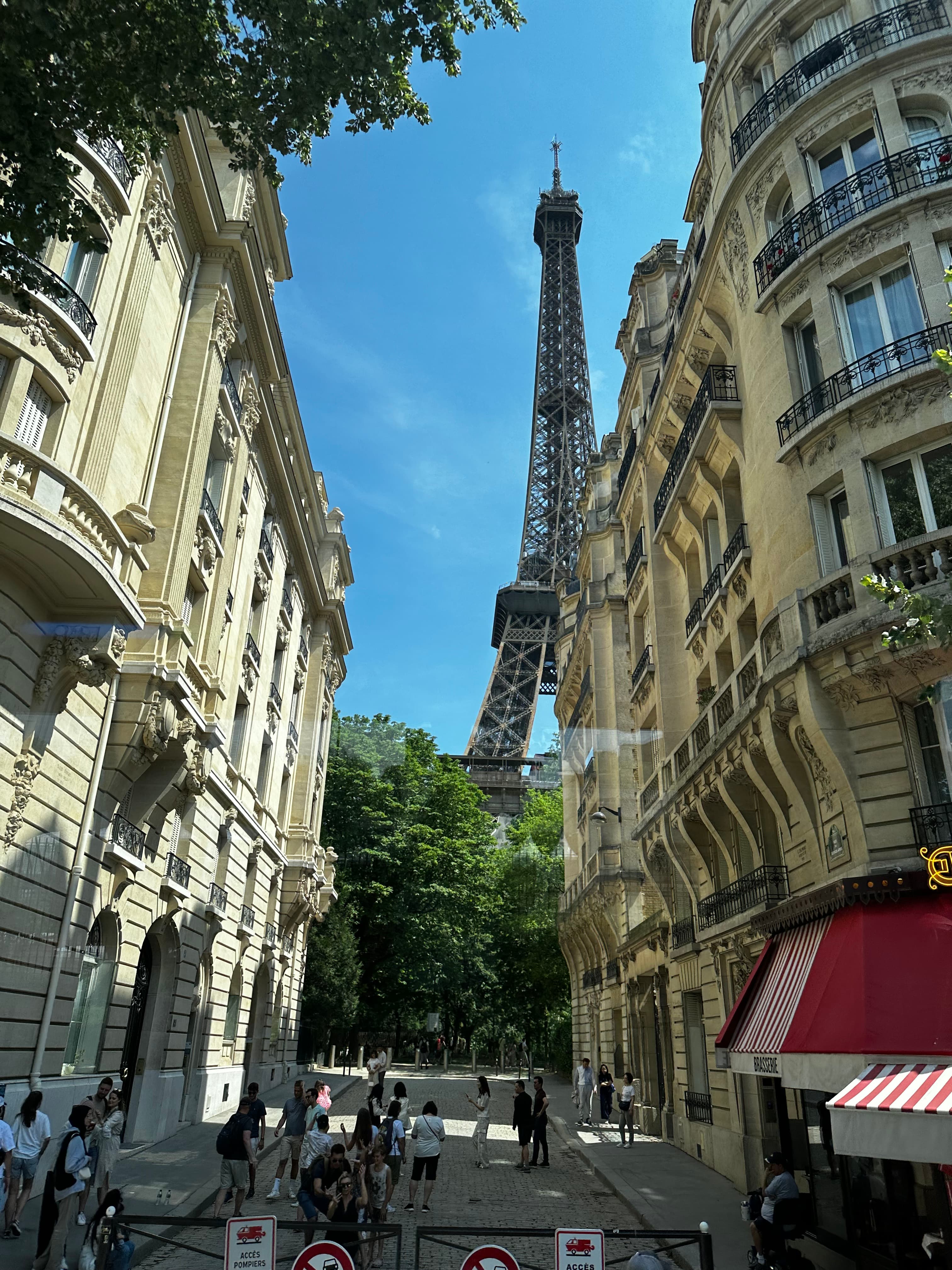 Pretty view of a street in Paris with the Eiffel Tower visible in the distance on a sunny day