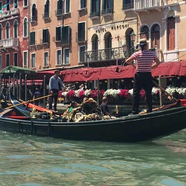 A gondola floating across the river in Venice.