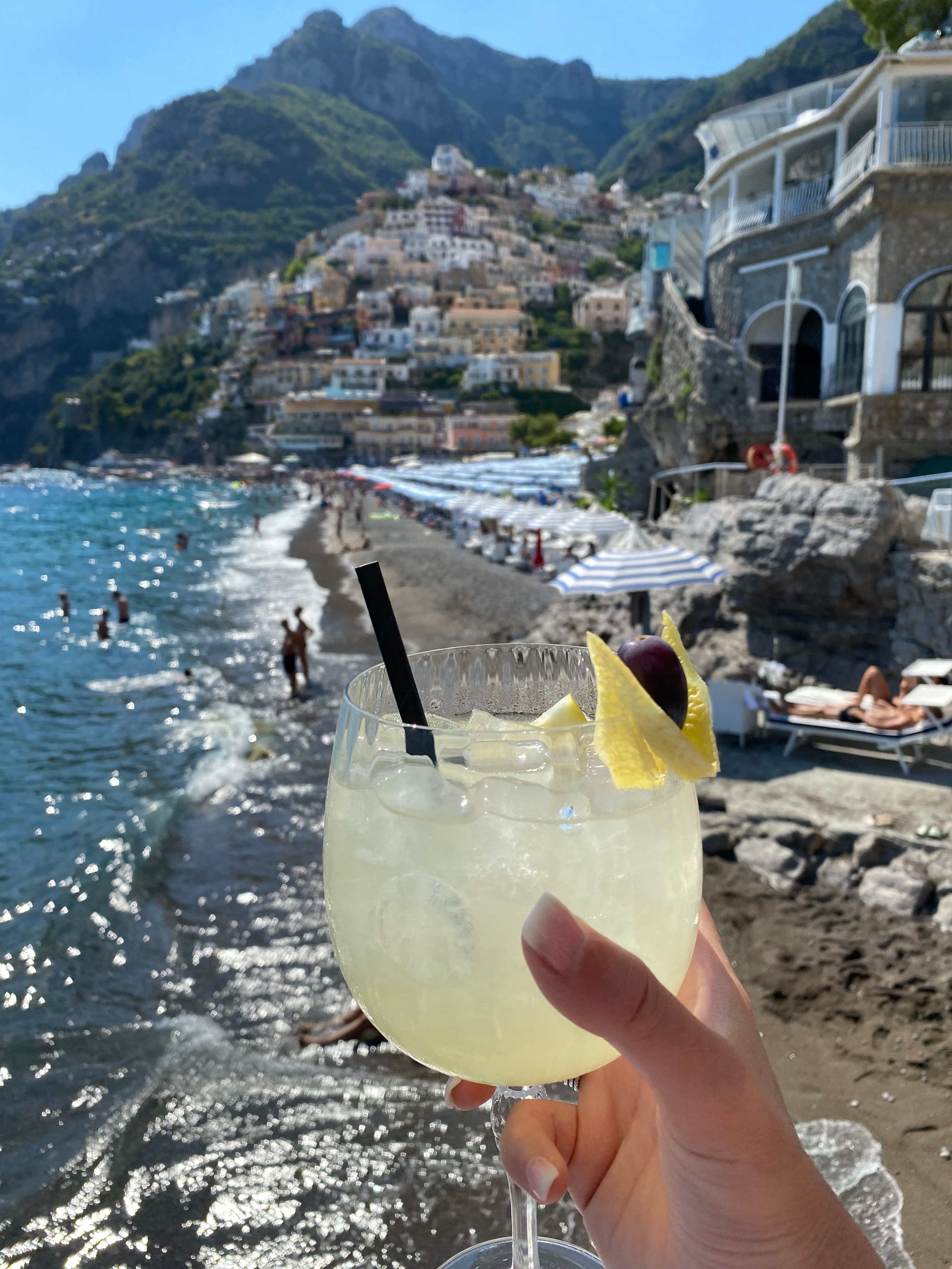 Cocktail with beach views and hills in the back.