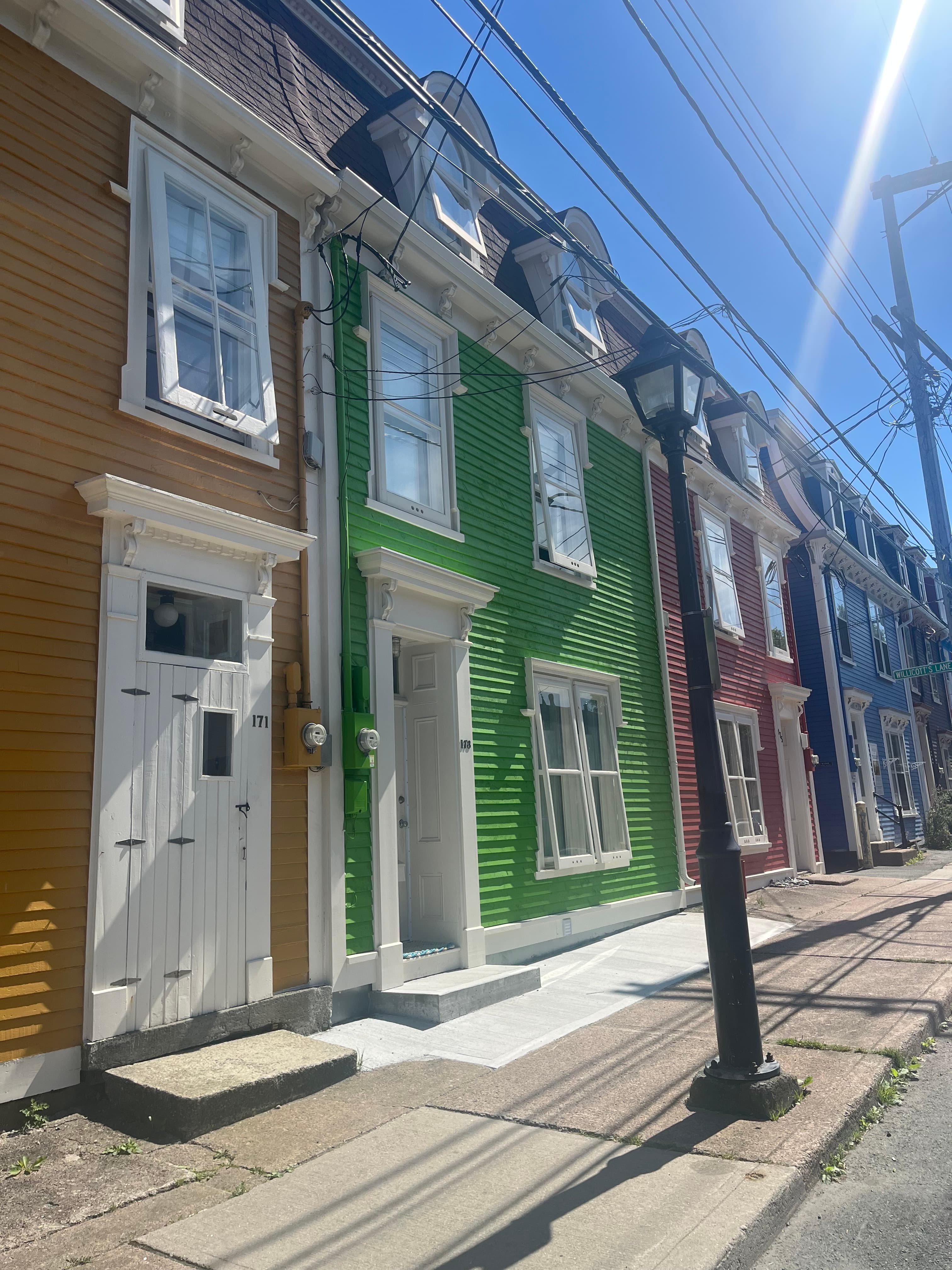 View of a colorful row of small buildings on a sunny, empty street