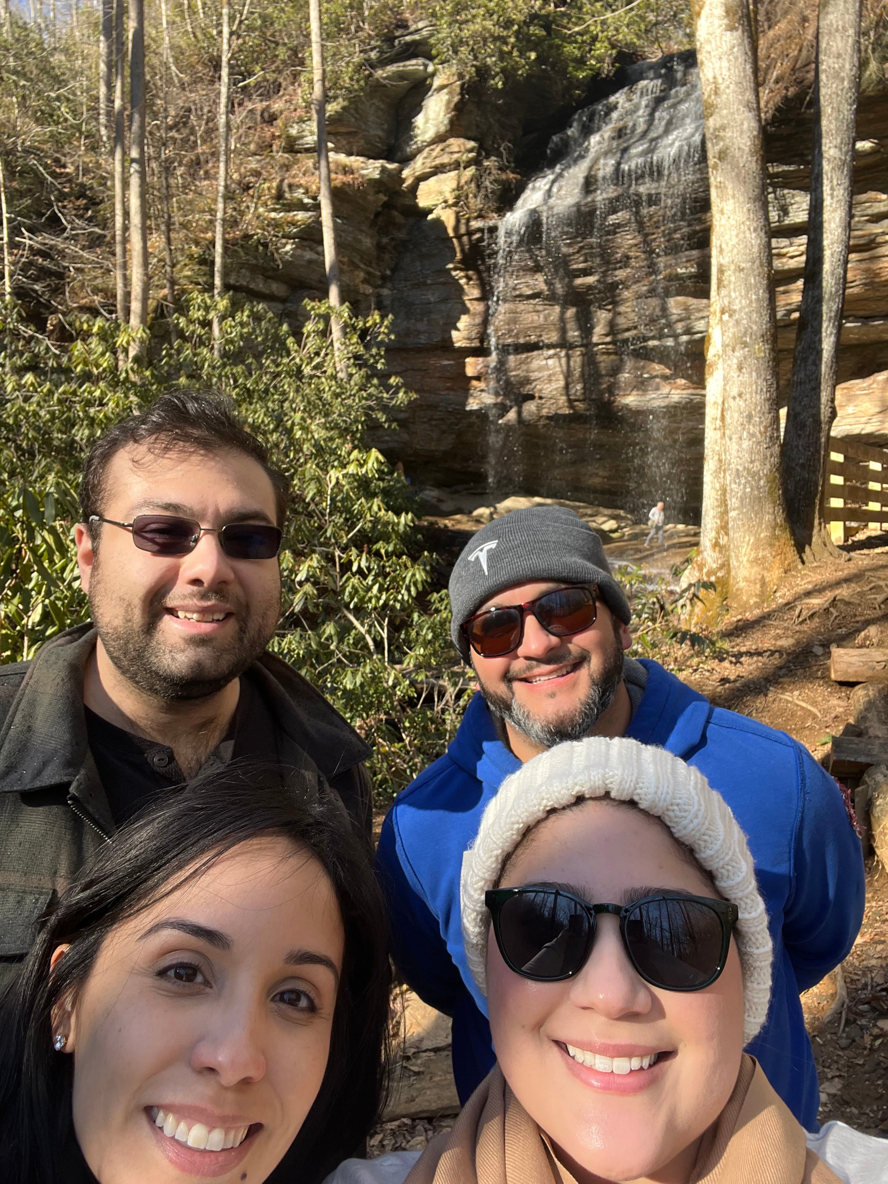 Friends in front of a waterfall.