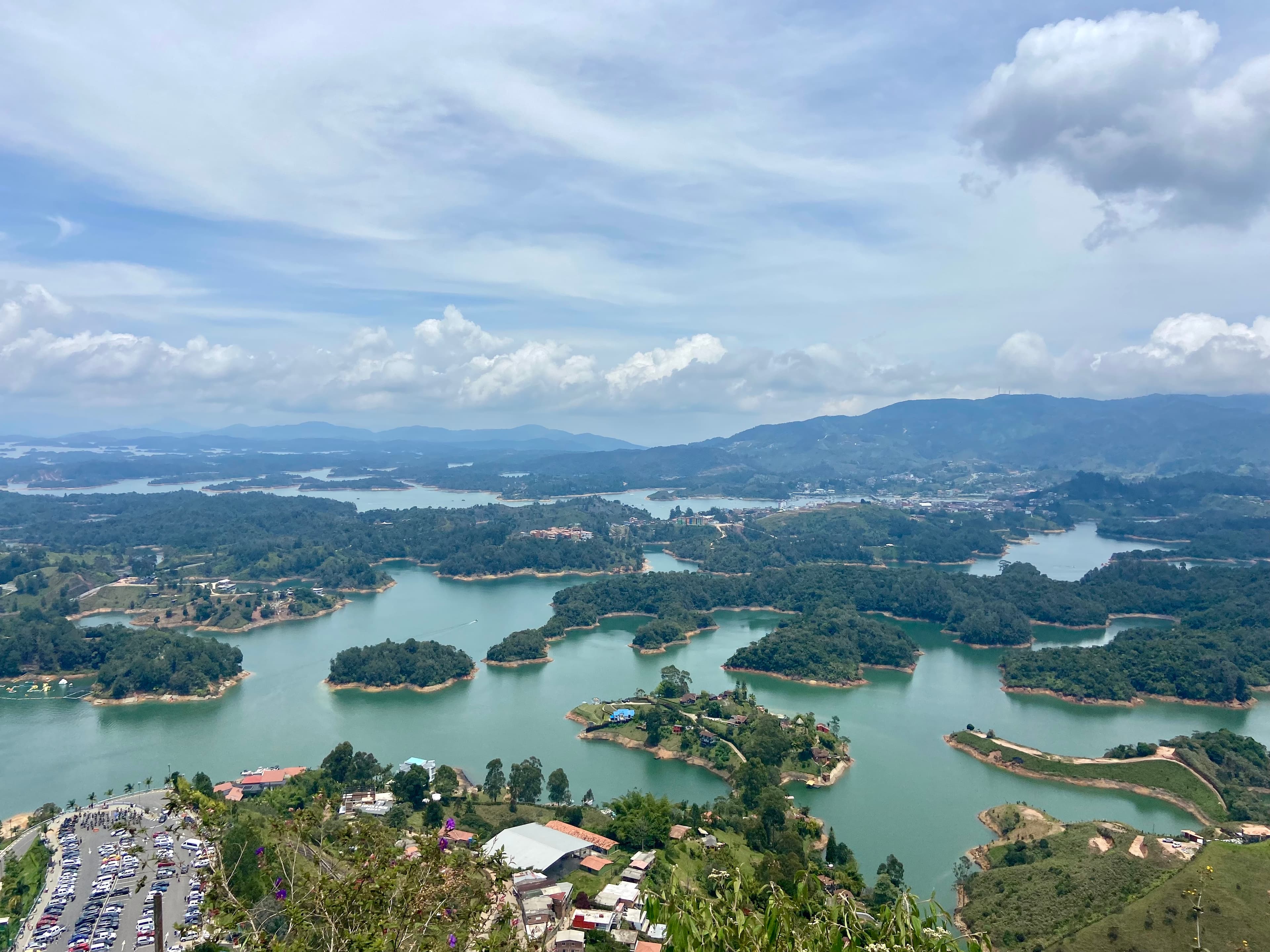 Aerial view of a body of water with several small island masses and mountains in the distance