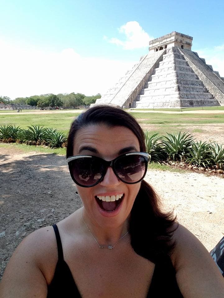 Advisor posing in front of ancient ruins on a sunny day.