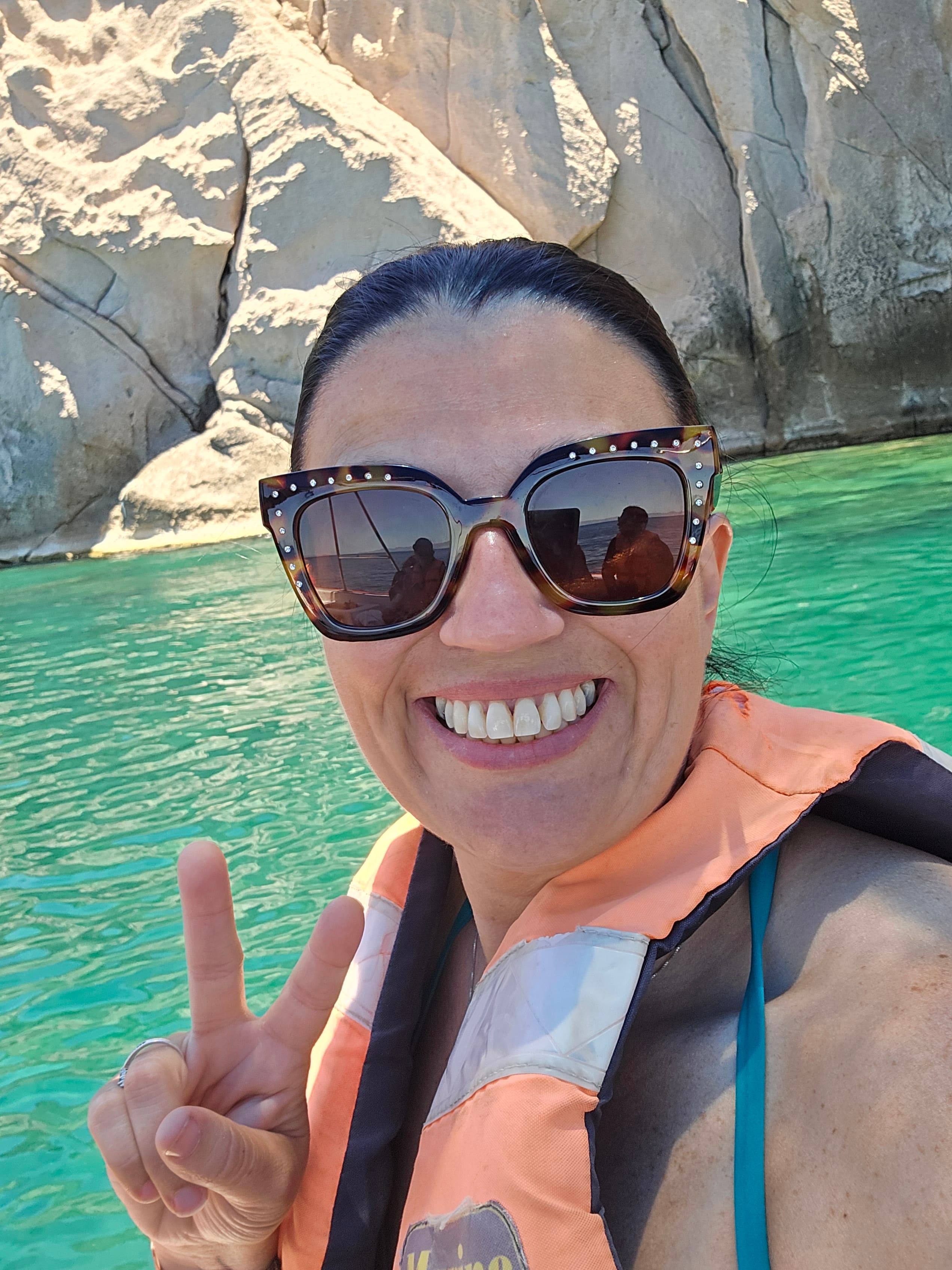 Advisor posing on a boat in front of waters.
