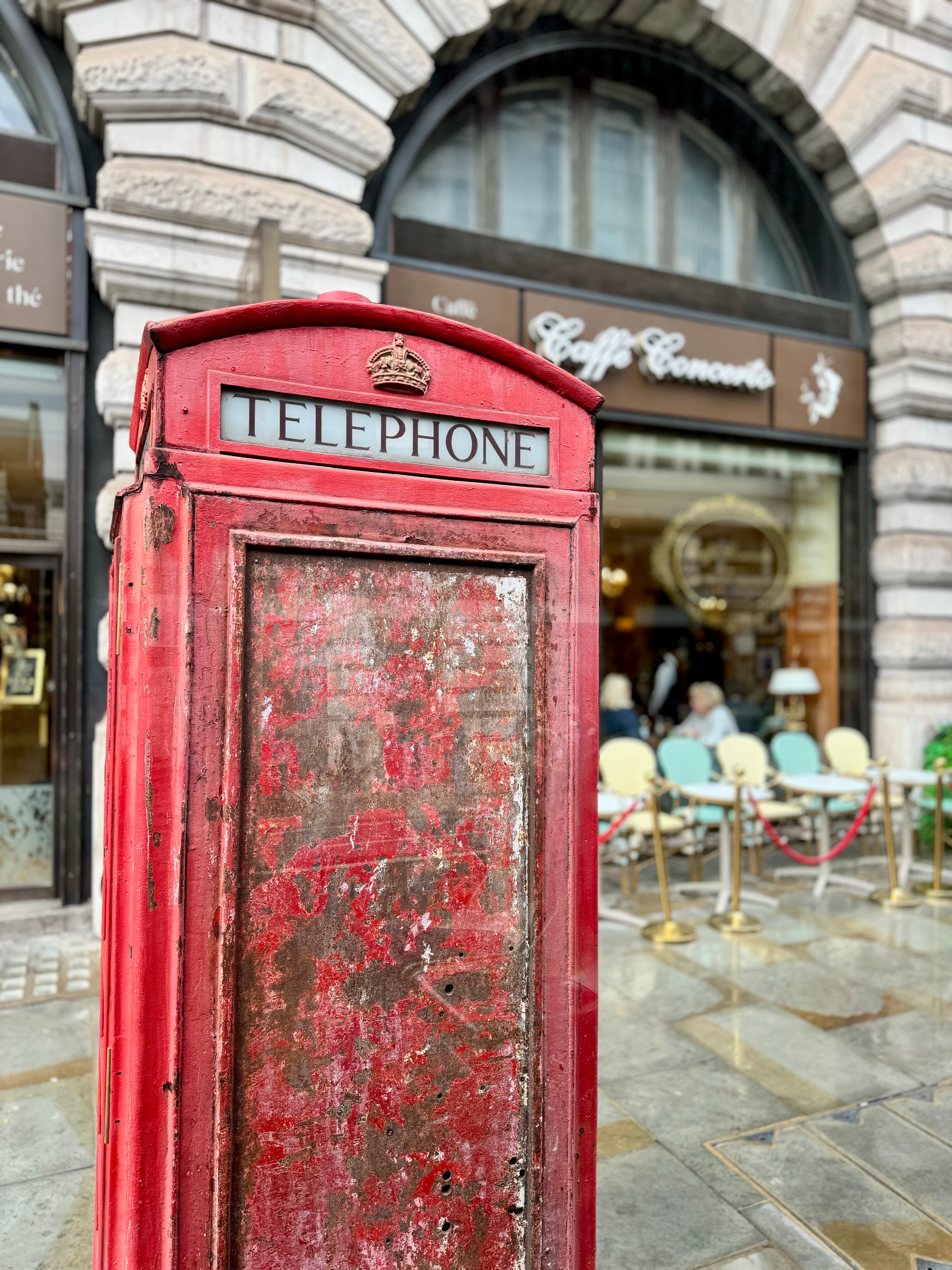 View of an old red telephone booth on a city street