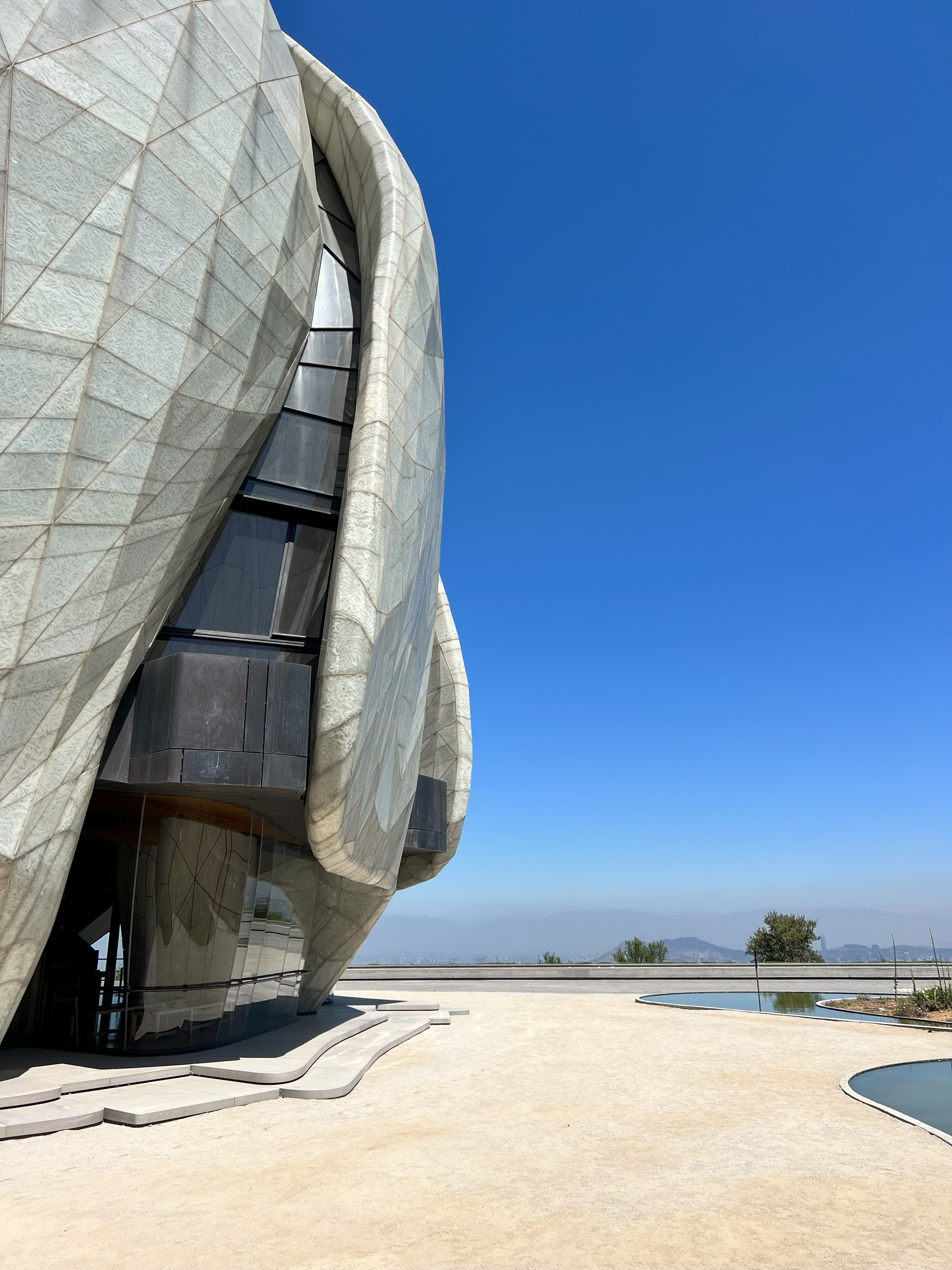 The side of a modern building beside a pool under clear skies