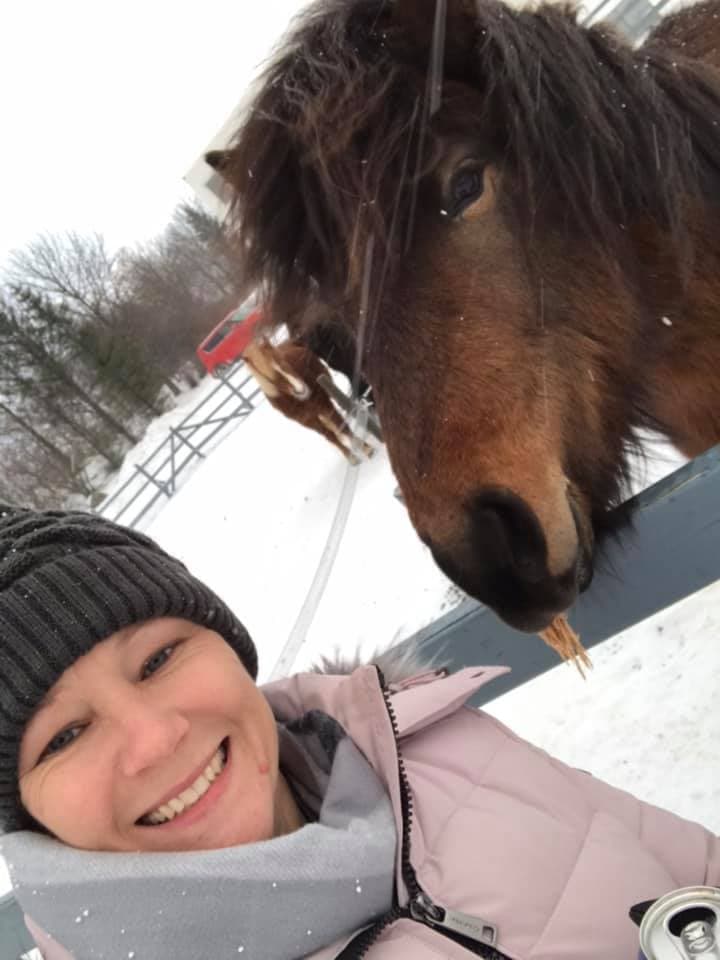 Advisor posing next to a horse in the snow.