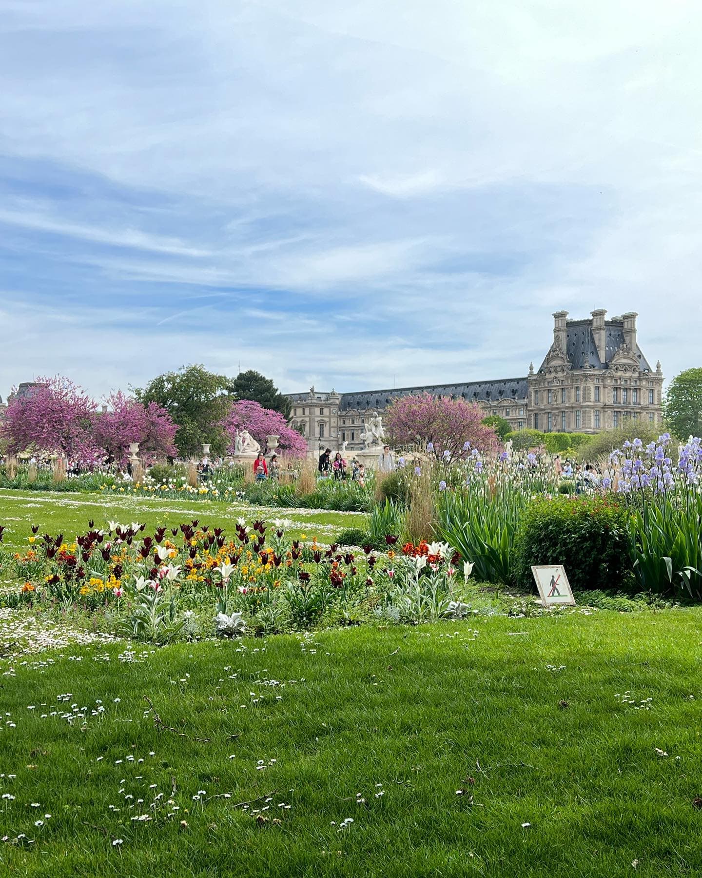 Lush gardens at the Louvre, featuring vibrant flowers and elegant pathways.