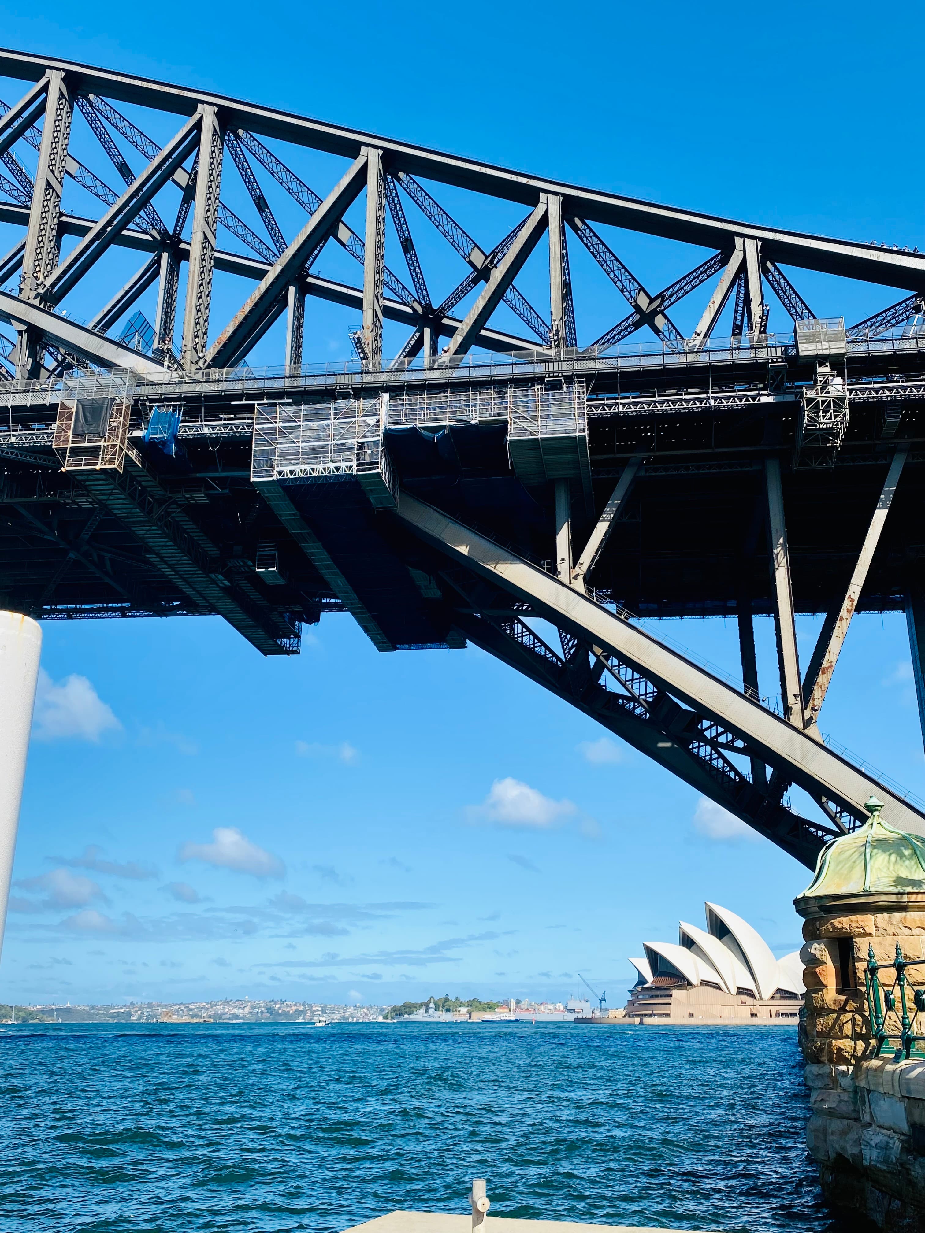 A view of a bridge with the ocean in the distance on a sunny day.