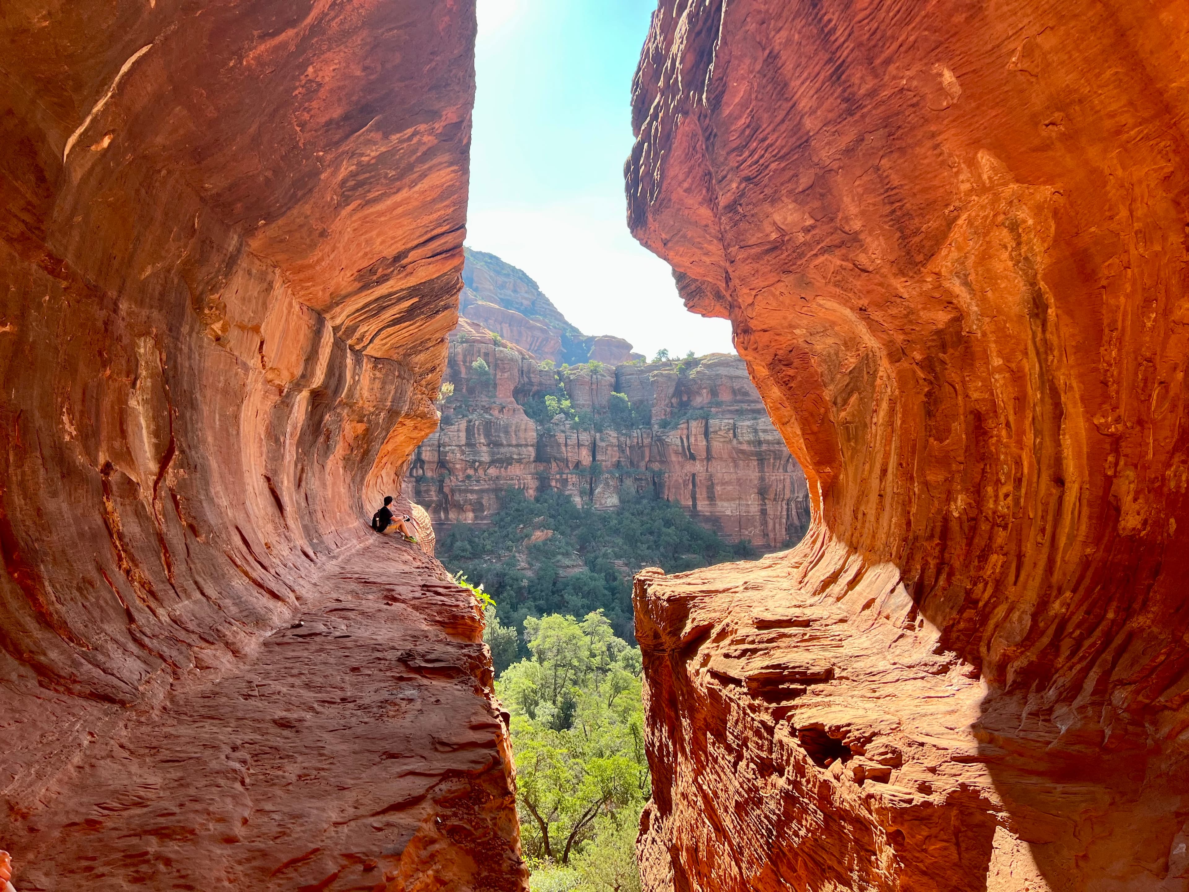 Beautiful image of a crevice in a red rock canyon revealing distant cliffs on a sunny day