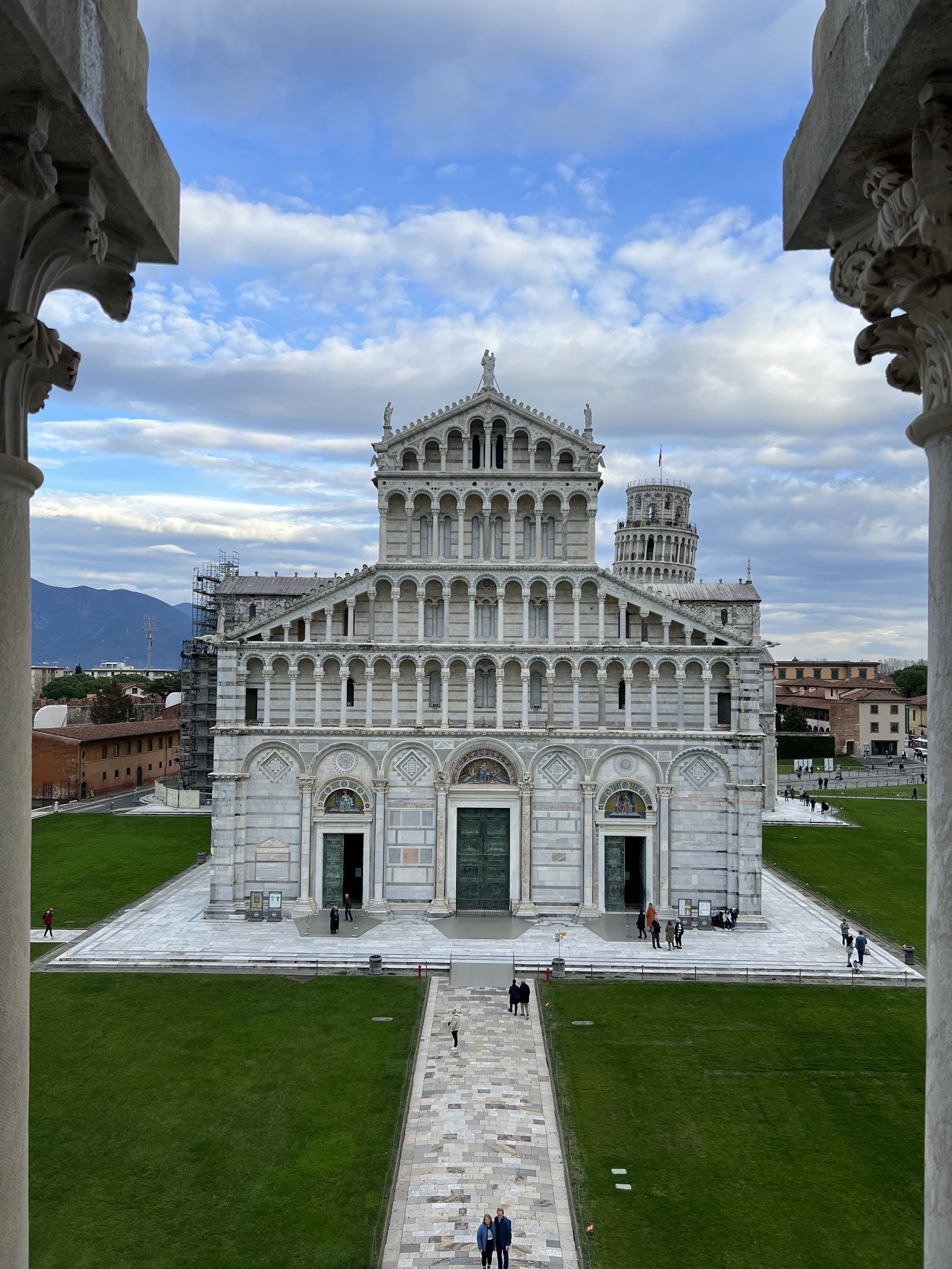 A beautiful white temple with a white path and manicured lawn in front of it.