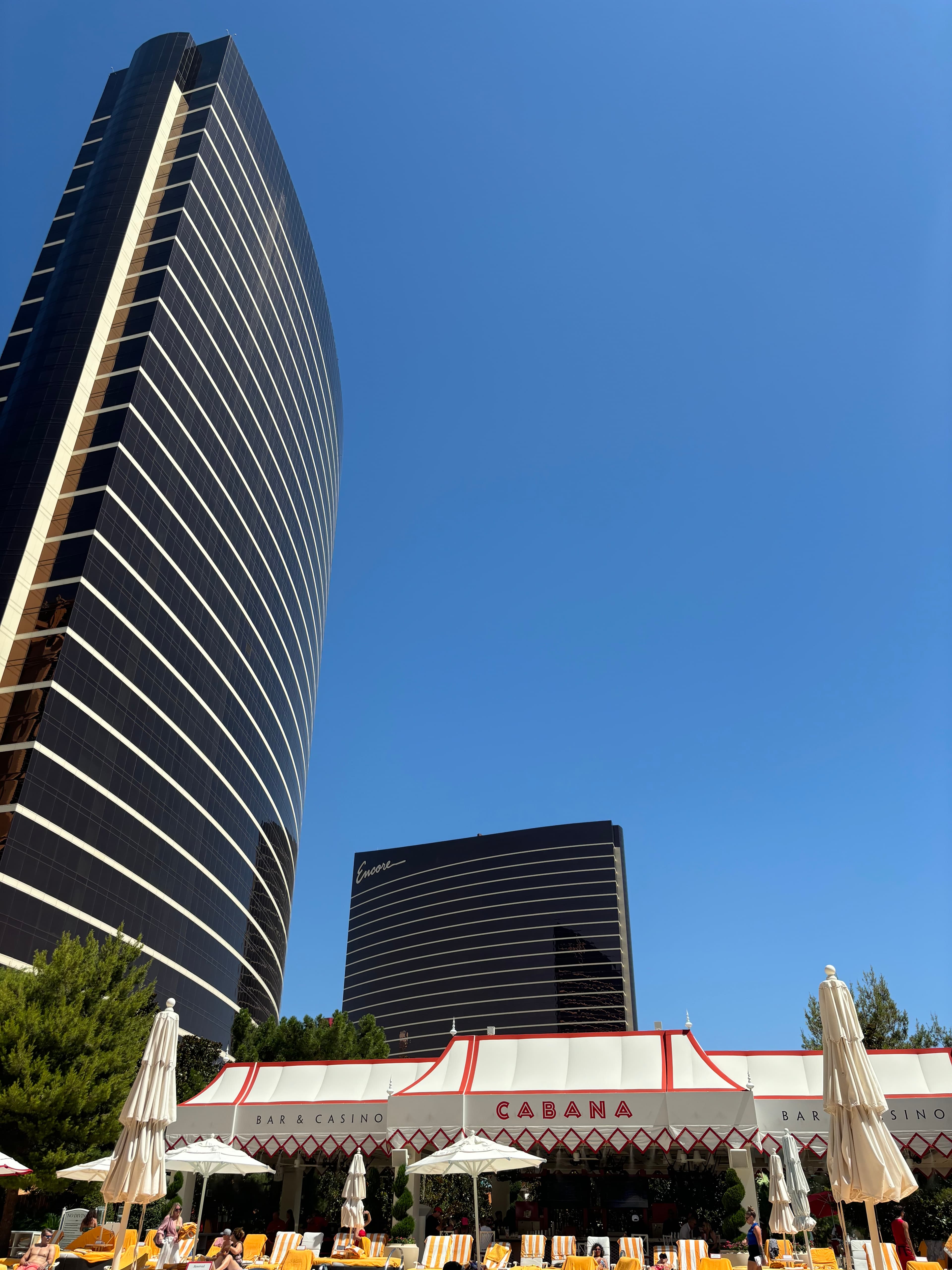Exterior of a shiny, modern skyscraper against a blue sky.