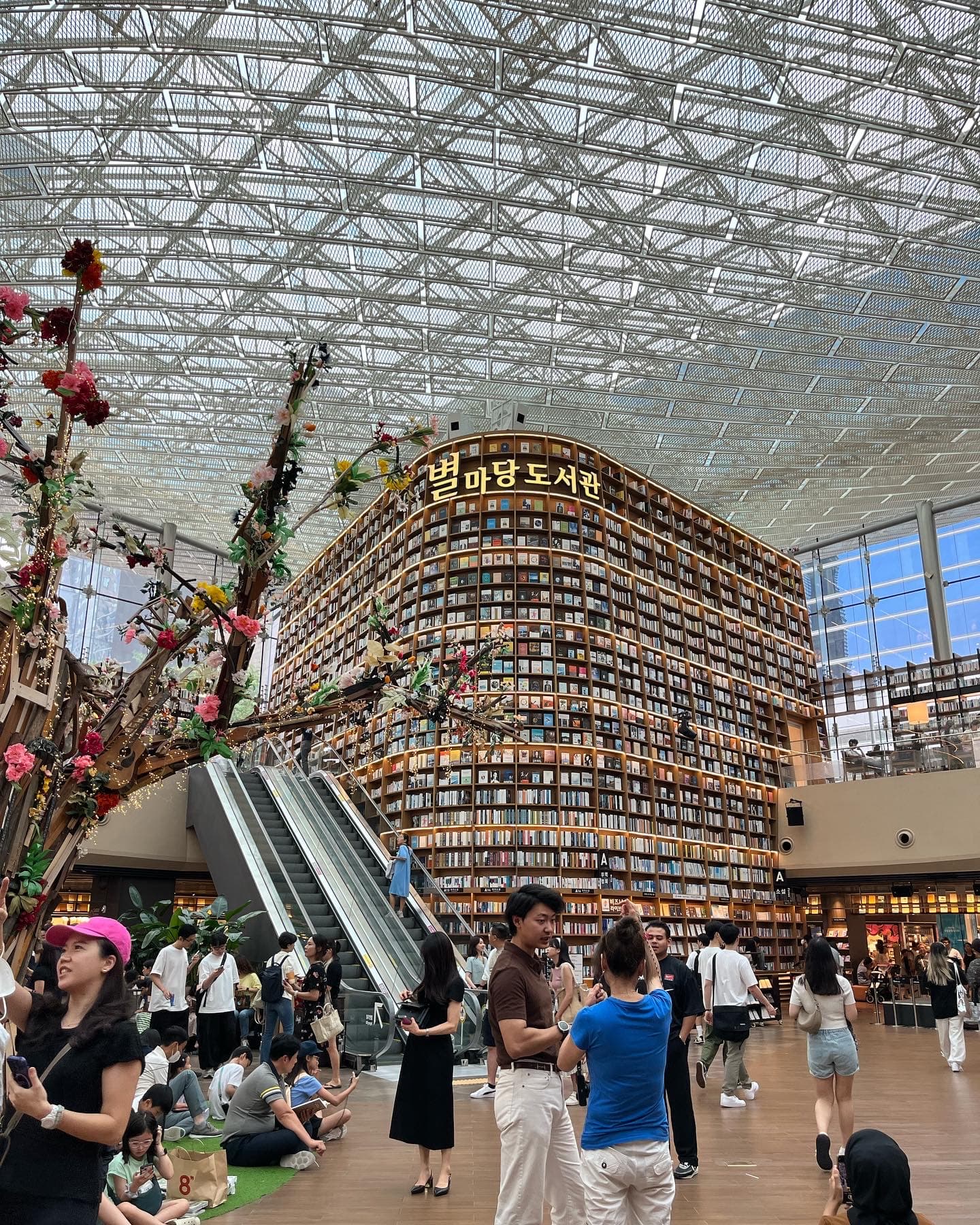 A bustling library with people walking around.