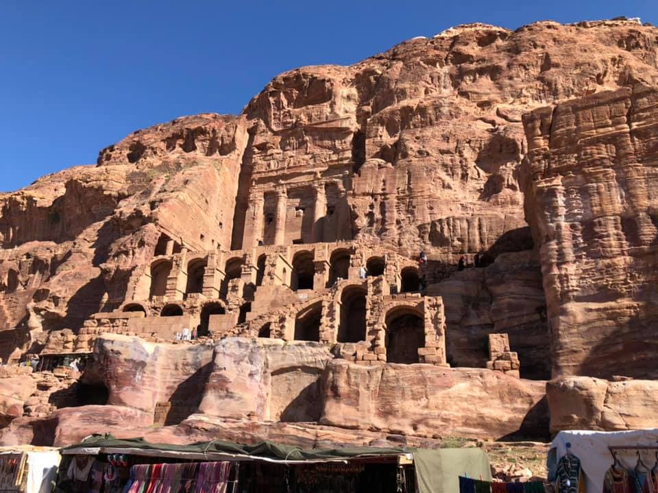 A view of an ancient village dug into a rock formation during the day.