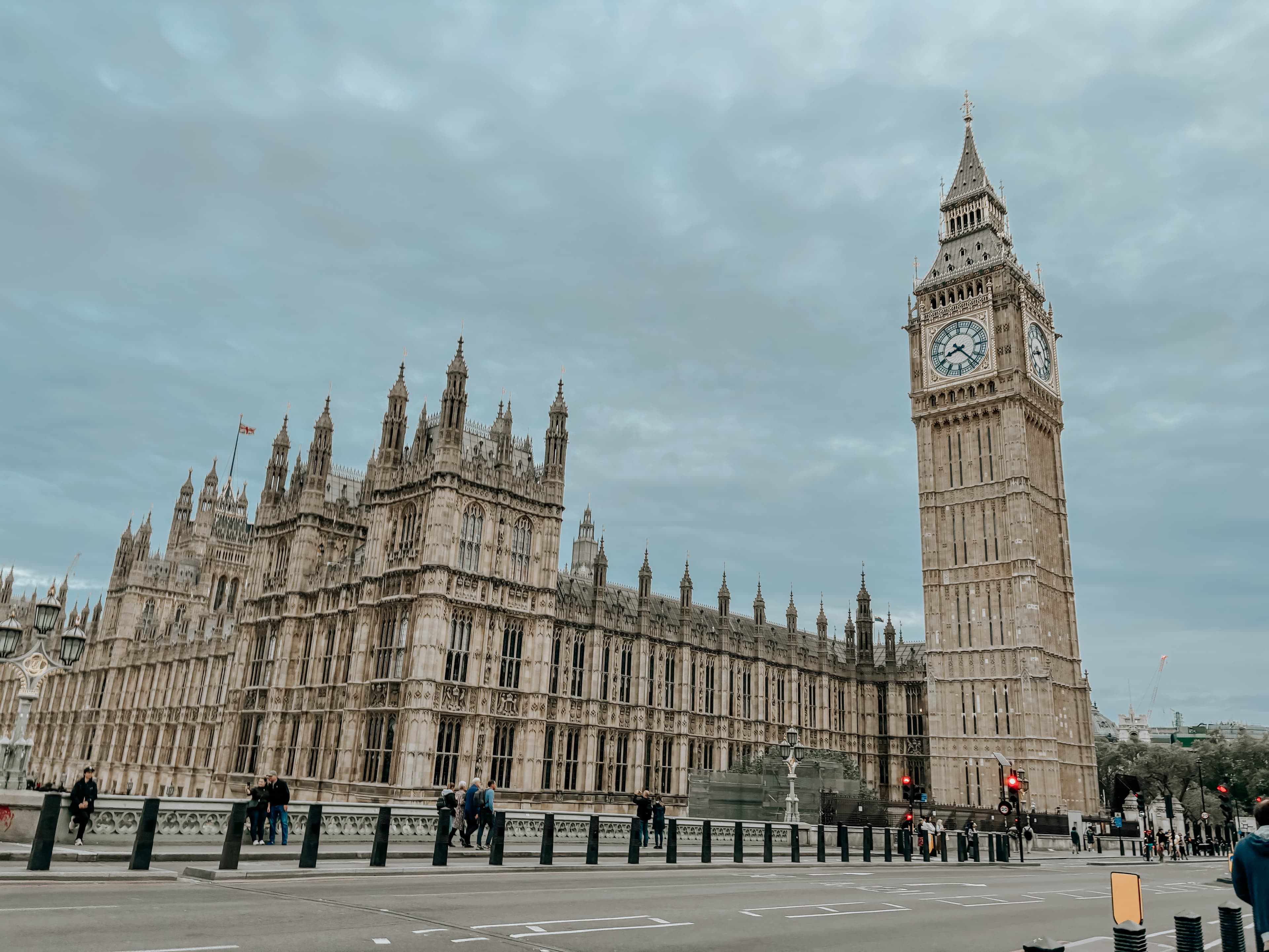 A city square with a large classic building in the distance on a sunny day.