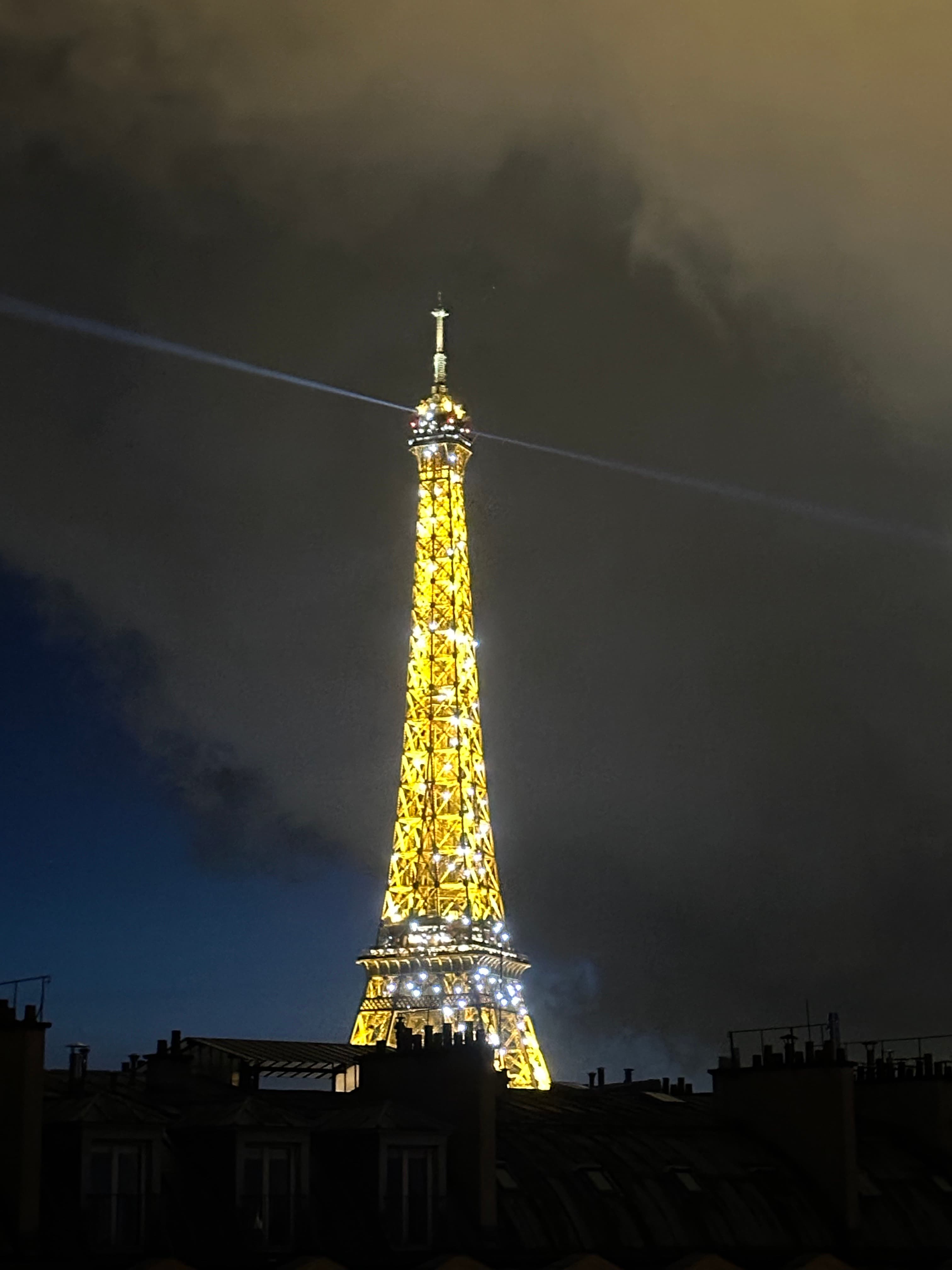 A view of the Eiffel Tower lit up at night.