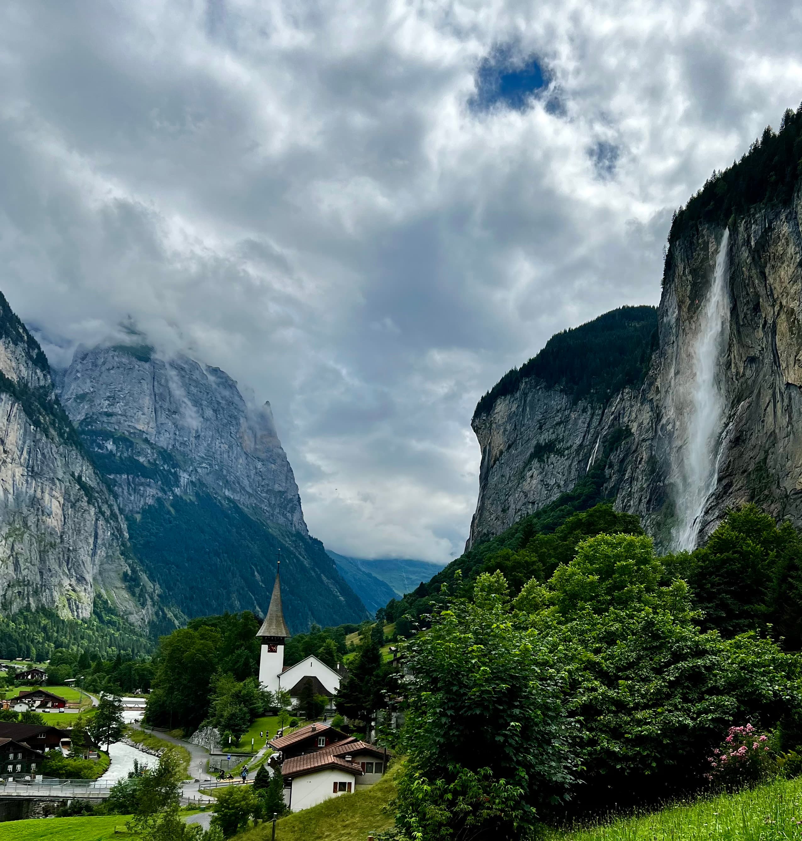 View of a waterfall in green valley on a cloudy day