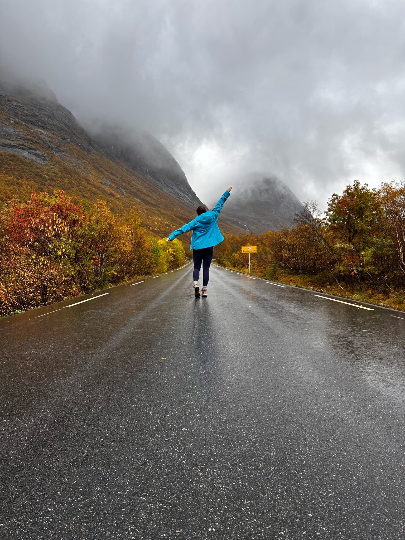 Advisor walking on an empty road through the mountains on a rainy day in autumn