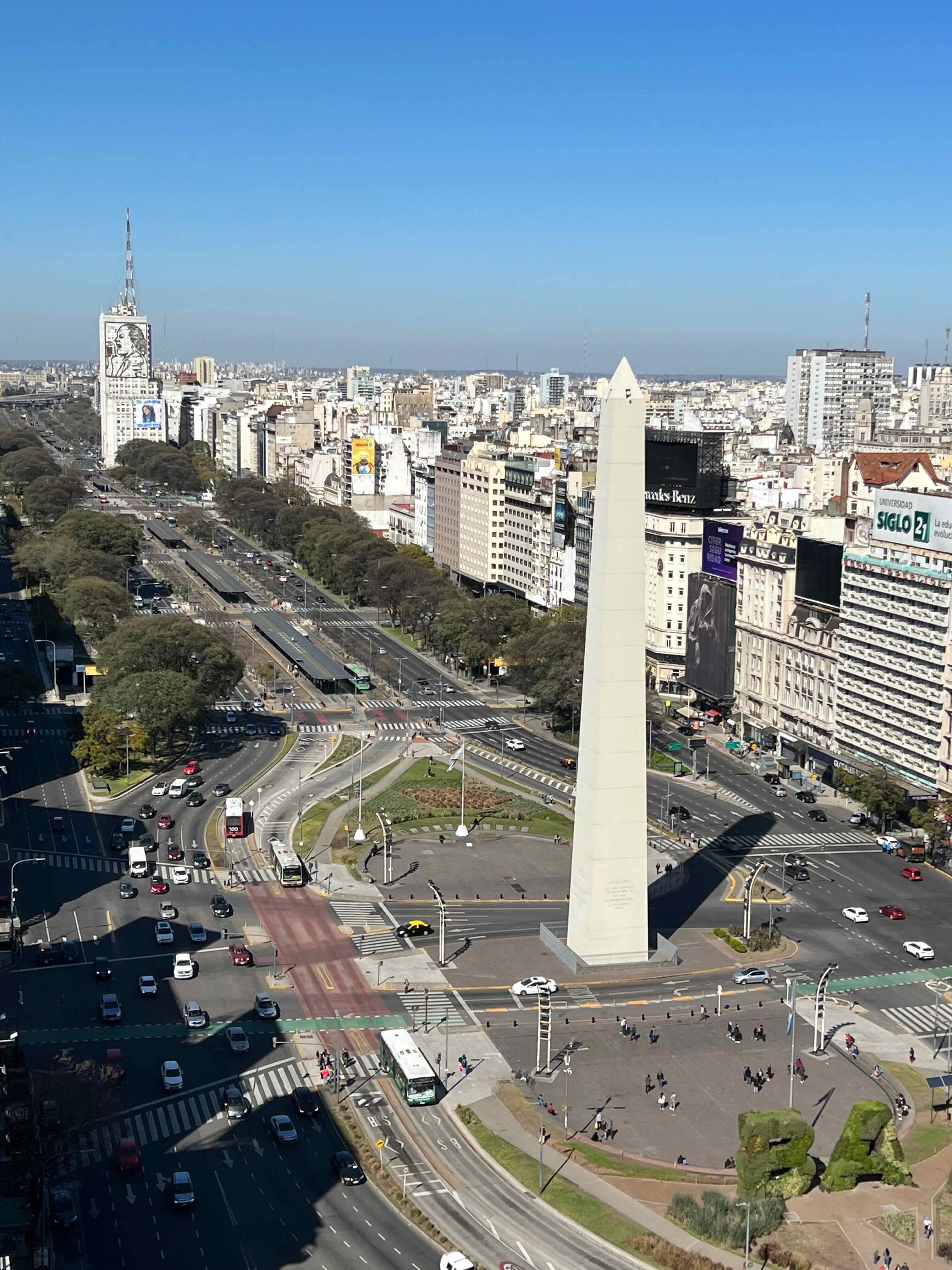 Aerial view of city streets and buildings lining an avenue on a sunny day