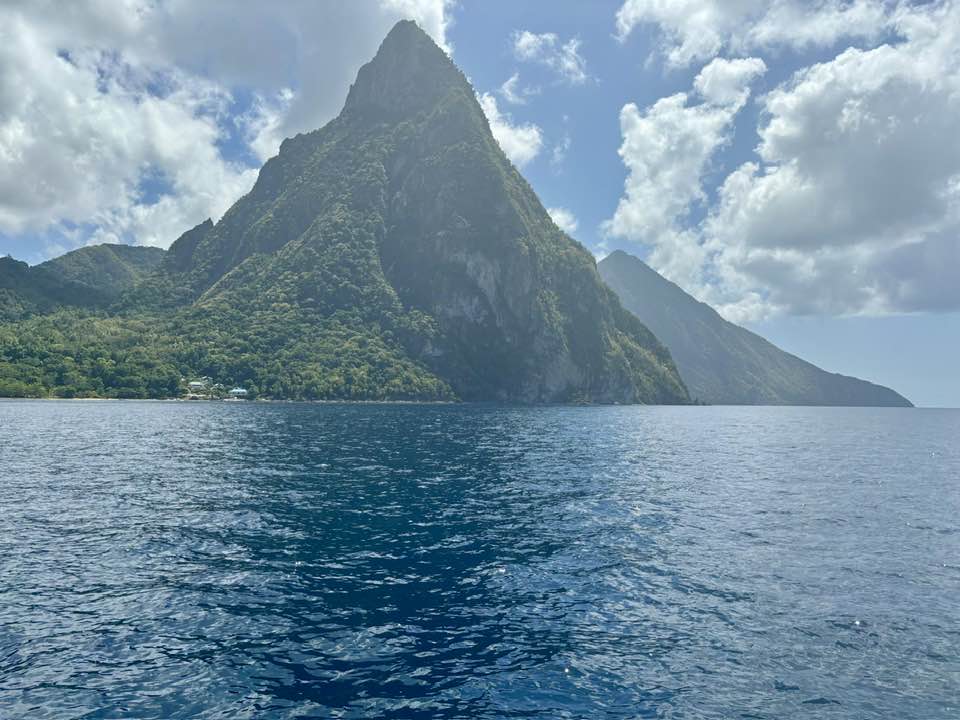 A view of volcanic rock over a body of blue water.