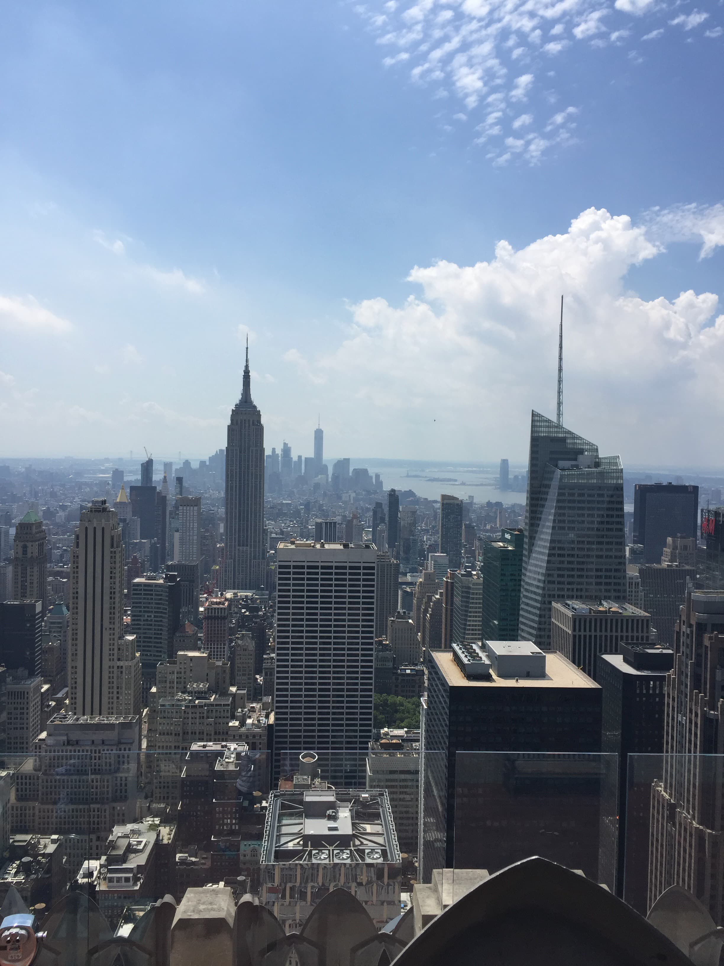 A city skyline stretches toward the horizon on a sunny afternoon.