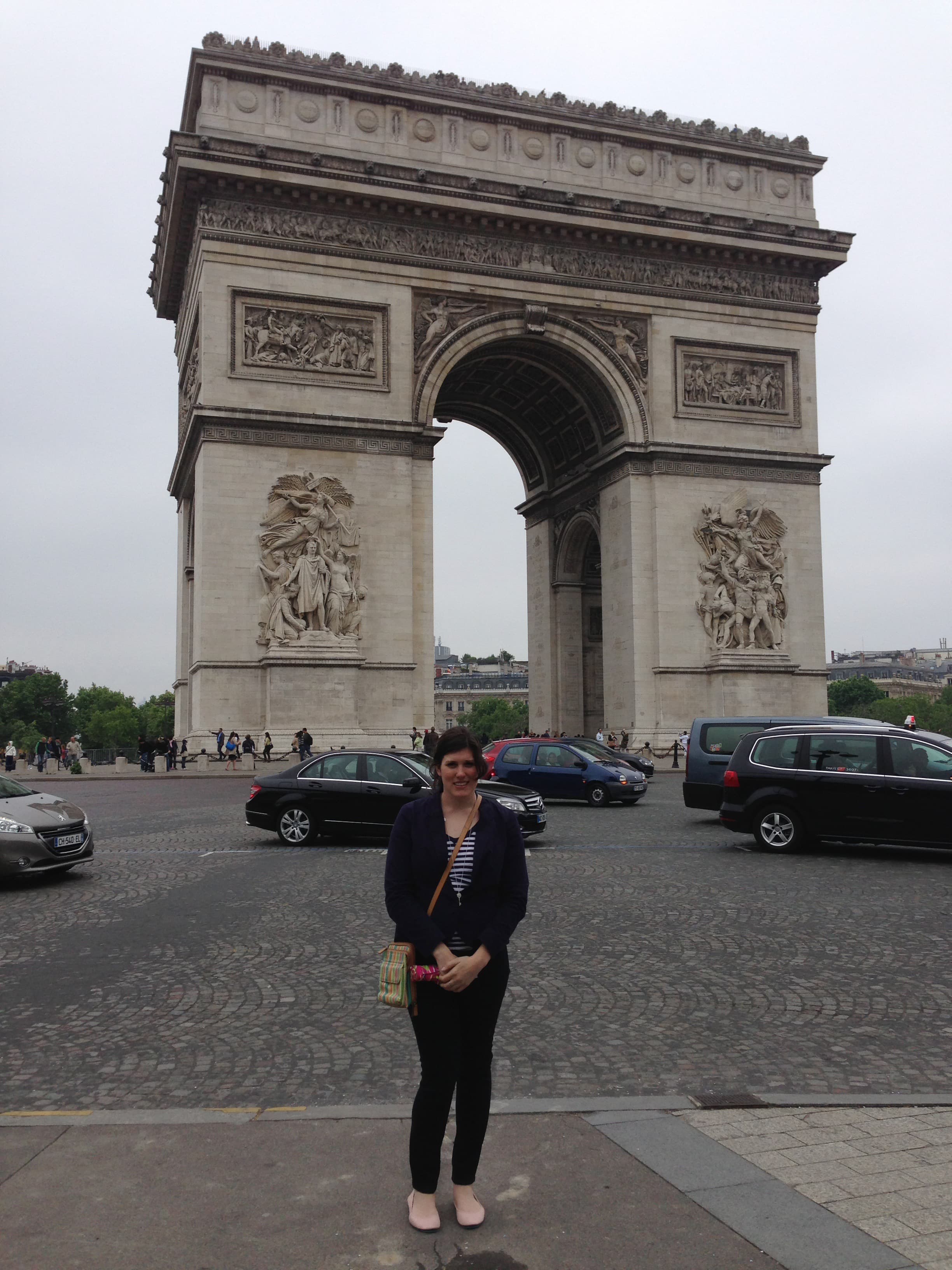 Advisor poses in front of historic arches on a cloudy day.