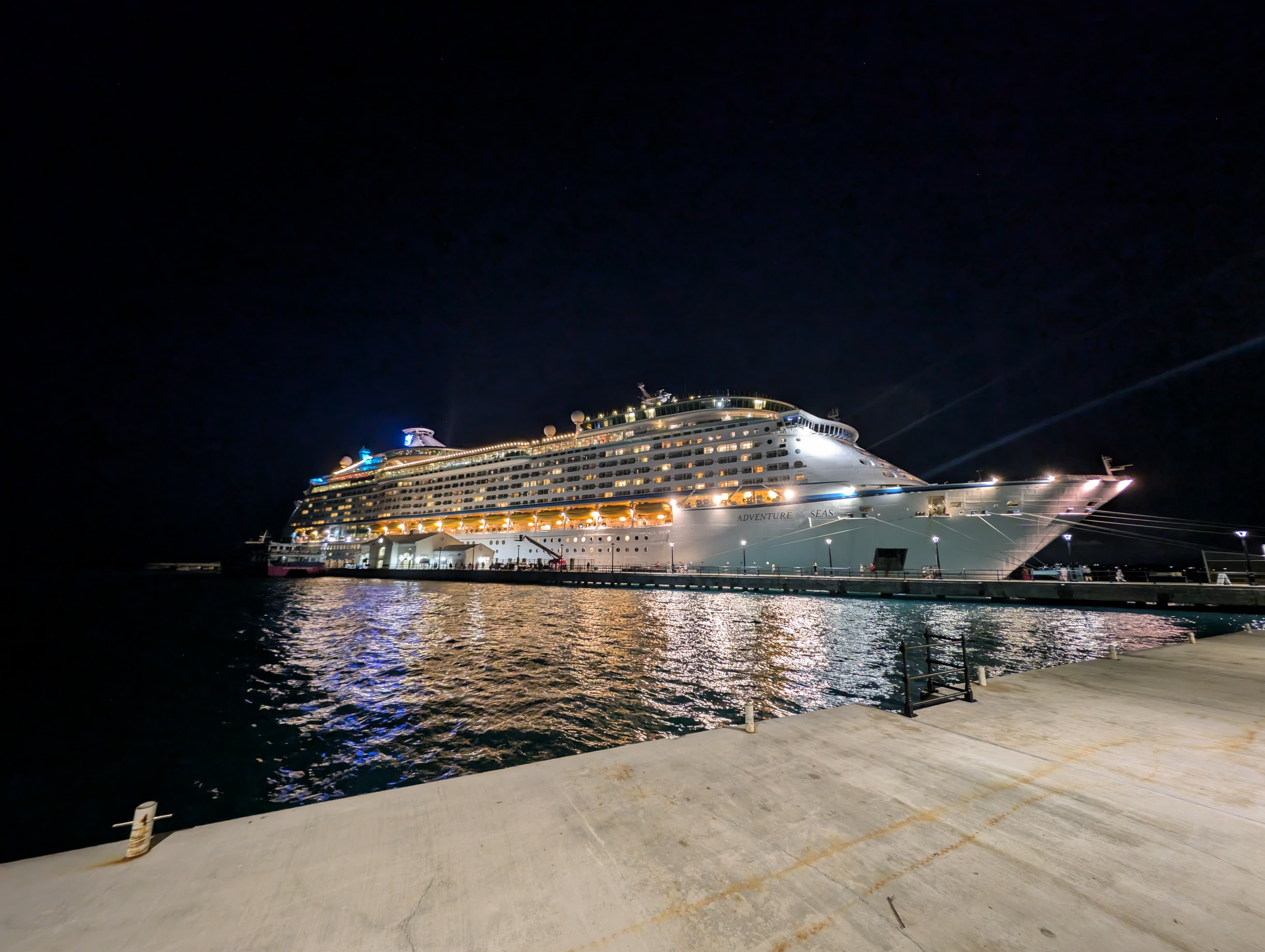 View of a large cruise ship in port lit up at against a pitch black night sky