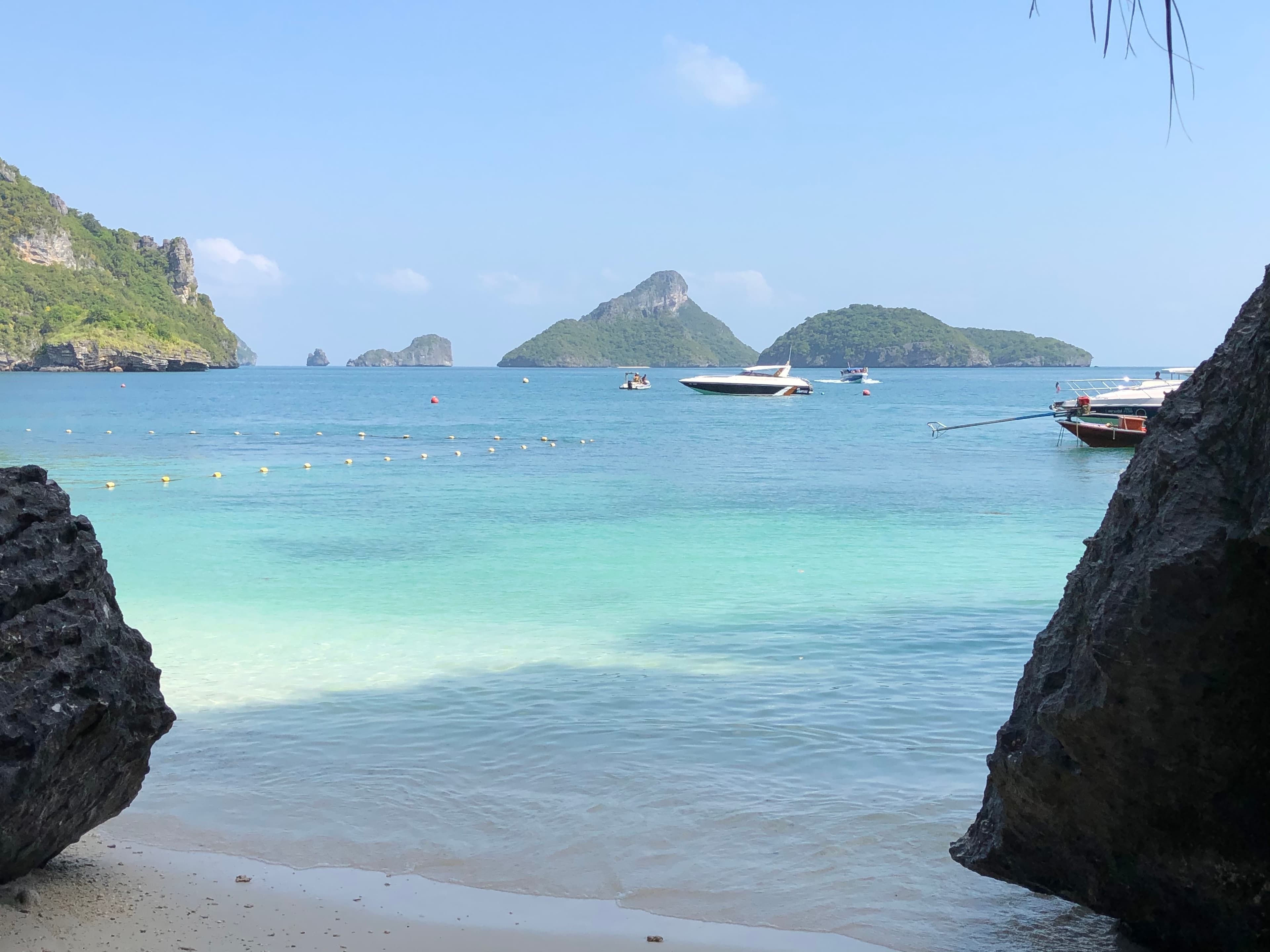View of the ocean and beach with rocks in Koh Samui on a sunny day
