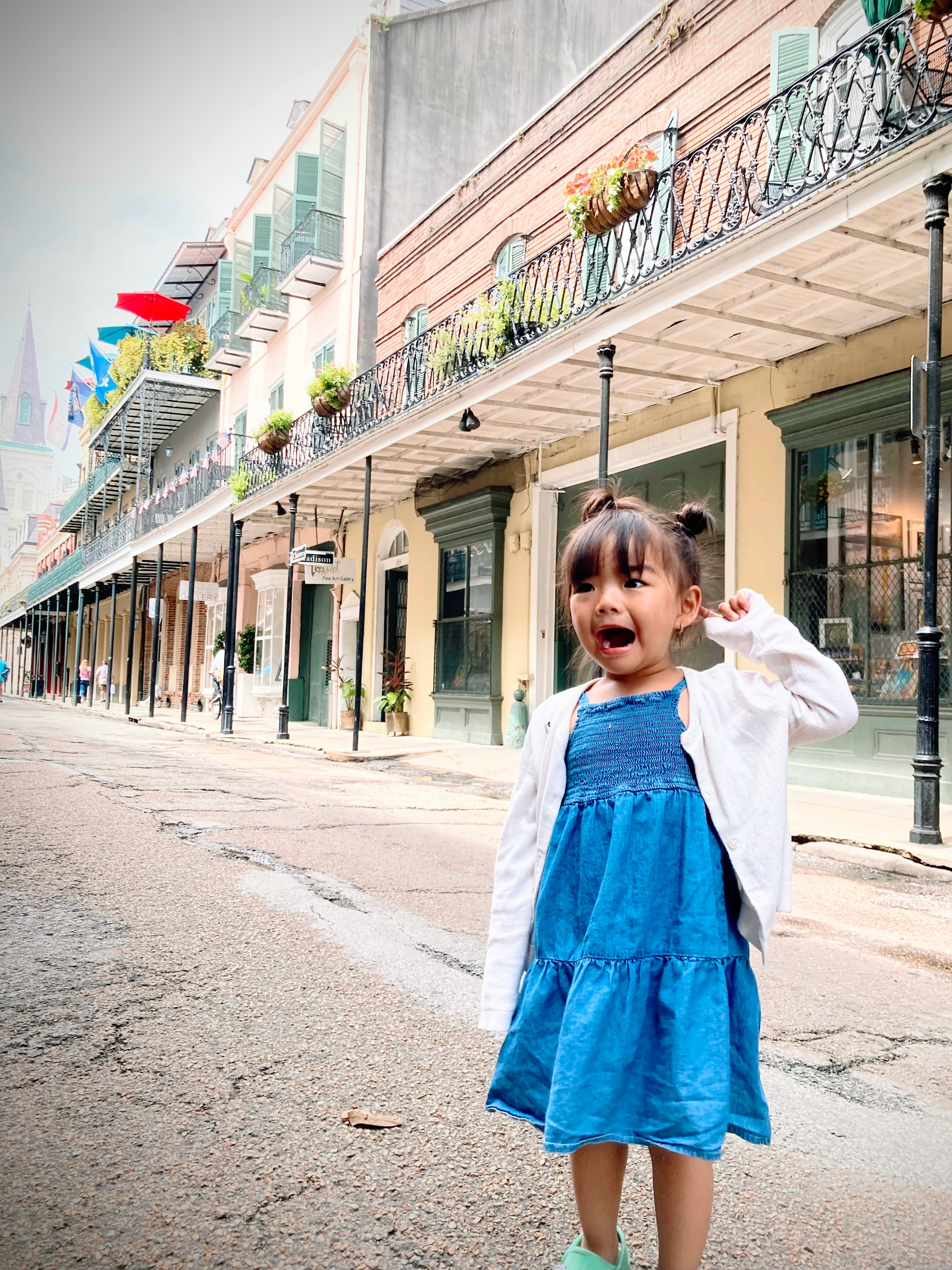 View of advisor’s daughter in a blue dress smiling on an empty city street