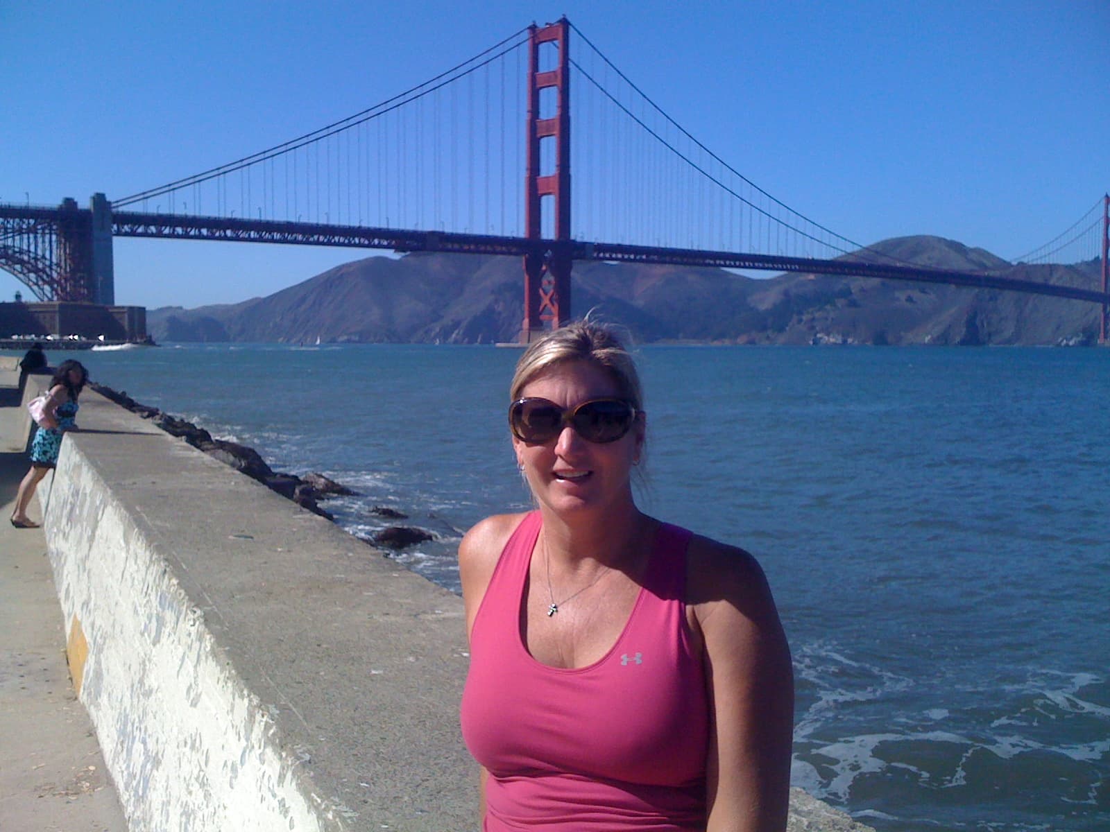 Advisor sitting by the sea with the Golden Gate Bridge behind her on a sunny day